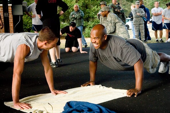 Staff Sgt. Jason Wells, left, and Tech Sgt. William Henderson from the 62nd Aircraft Maintenance Squadron, perform push-ups during a Red Cross fundraiser sponsored by the First Sergeant Council. (U.S. Air Force photo/Abner Guzman) 