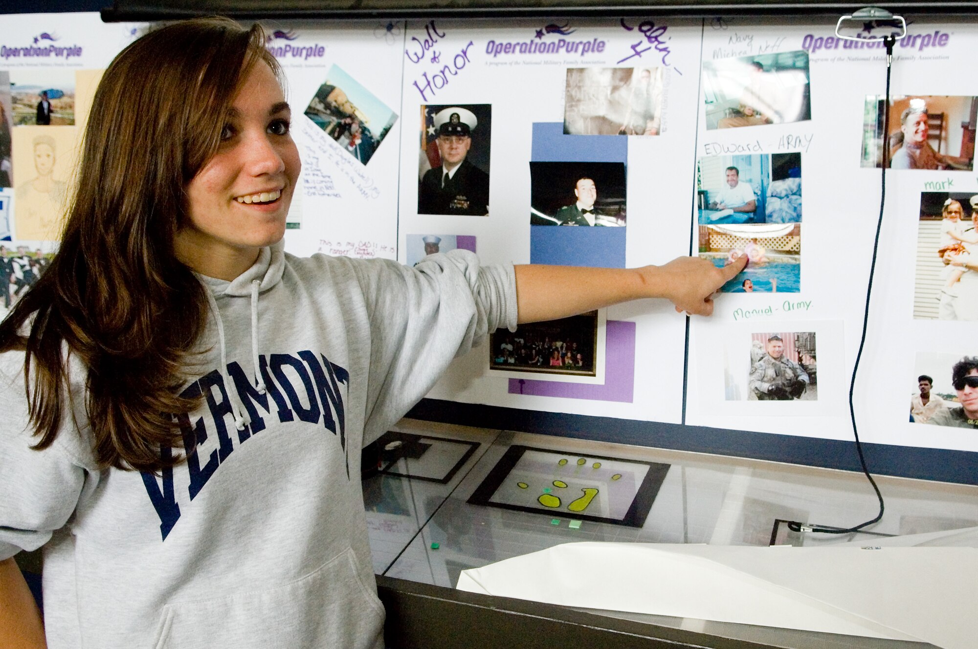 Shauna Binkowski, 16, of Fort Lewis points to a photo of her father on the camp’s Wall of Honor. Binkowski’s father is an Army warrant officer assigned to Fort Lewis.