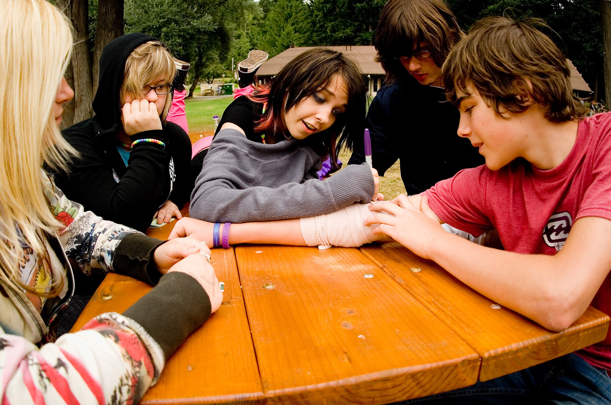 New friends gather around camper Jordan Brian to sign his cast during camp.