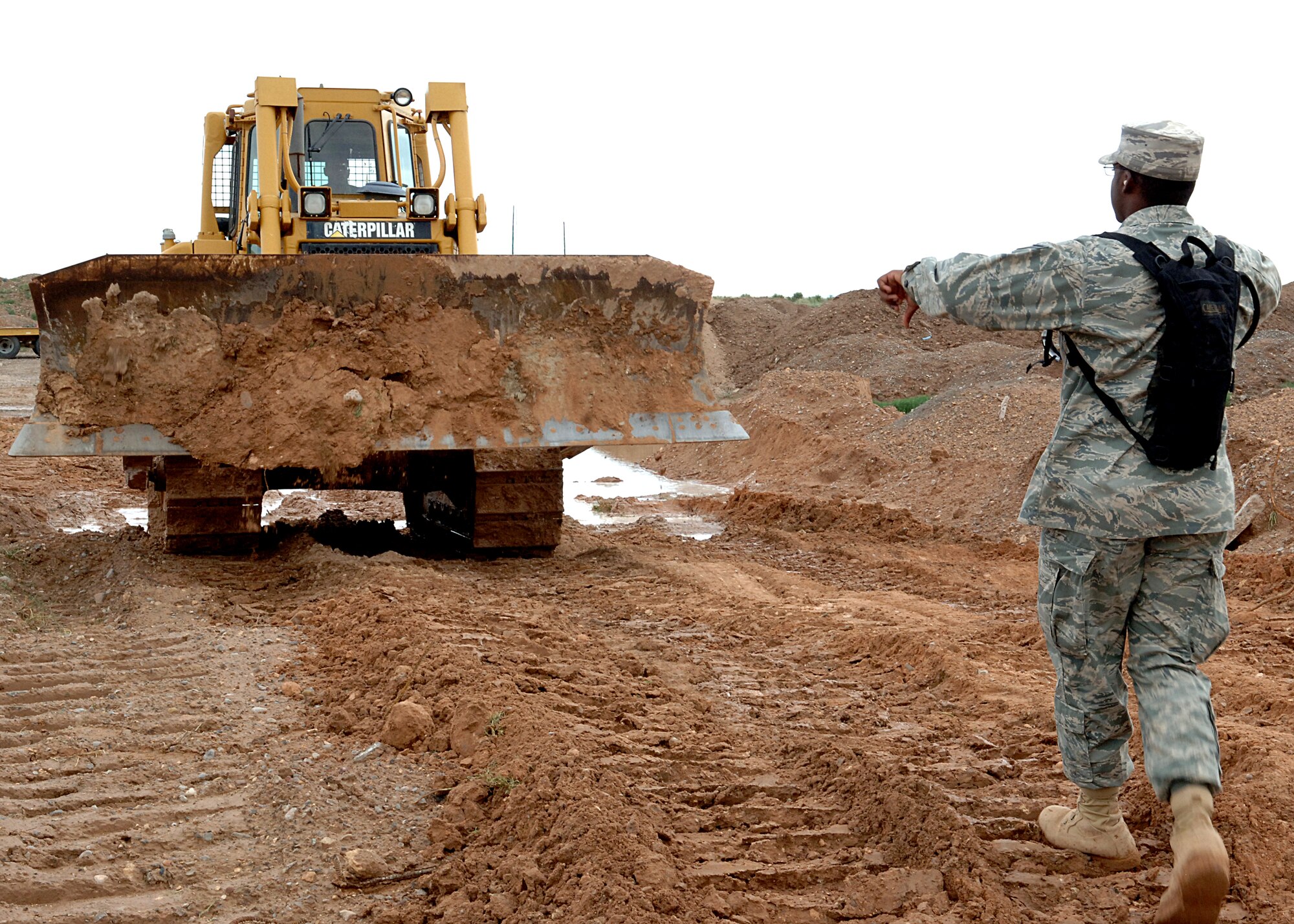 Airman 1st Class Daquan Mclain, 49th Civil Engineer Squadron, instructs Staff Sgt. William Hyche, also from the 49th CES, where to unload the dirt Aug. 16 at the ATV track at Holloman Air Force Base, N.M.  The Heavy Repair shop smoothed out the roads, curves and jumps on the track in order to make the track better, faster and, most importantly safer.  (U.S. Air Force photo by Airman 1st Class John D. Strong II)