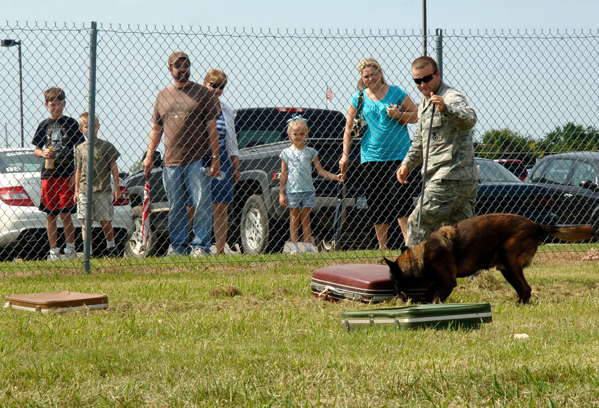 MCCONNELL AIR FORCE BASE, Kan. -- Staff Sgt. Matthew Mosher, 22nd Security Forces Squadron, and military working dog, Bram, demonstrate explosive detection for spectators at the Colonel James Jabara airport during the Wichita Flight Festival, Kan. Aug. 23. Bram, who recently returned from a deployment, can detect explosive material hidden within multiple suitcases. (Photo by Senior Airman Laura Suttles)