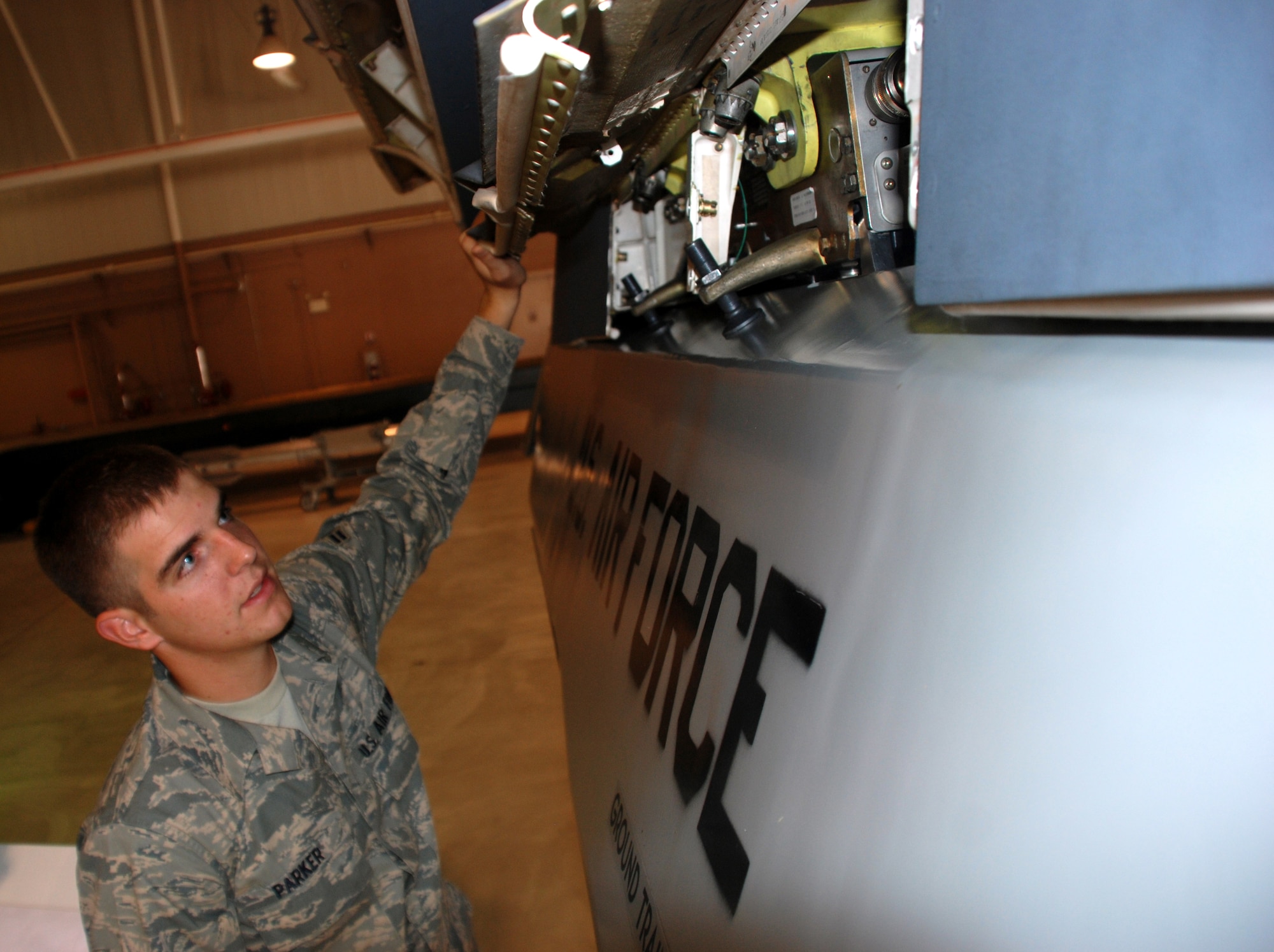 Airman 1st Class, Seth Parker, a nuclear maintenance technician student at the 363rd Training Squadron, inspects the connection between a bomb and pylon Aug. 20 during a training session. Sheppard is home to the Air Force's nuclear weapons training programs. (U.S. Air Force photo/John Ingle)