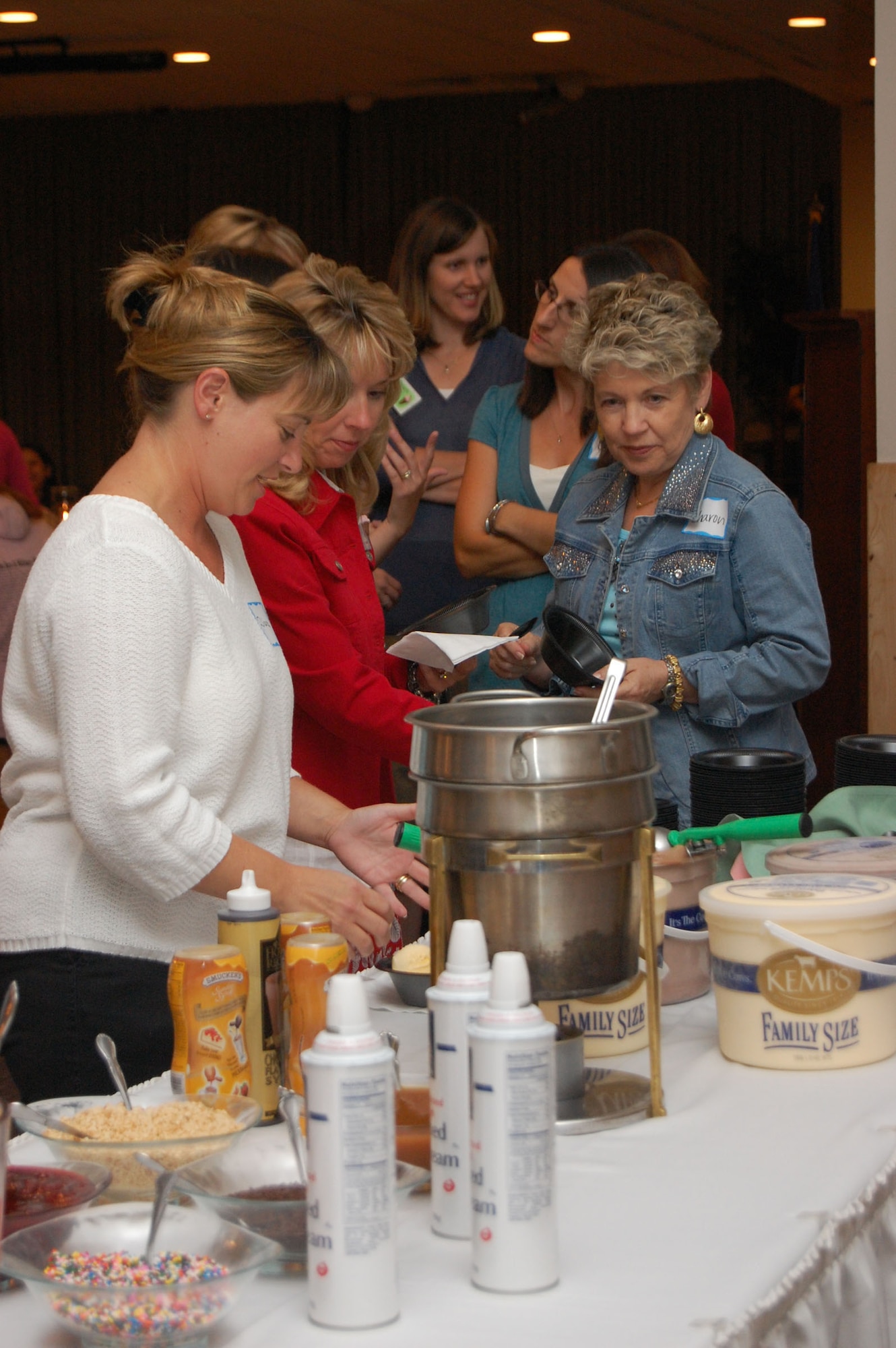 Diana Kelch, Julie Dodge and Sharon Gotcher dig in to the ice cream during the Malmstrom Spouses Club Ice Cream Social at the Grizzly Bend Club Aug. 21. The social was held to give members and non-members a chance to socialize and see what the MSC has to offer. More than 50 spouses were in attendance. (U.S. Air Force photo/Senior Airman Emerald Ralston)