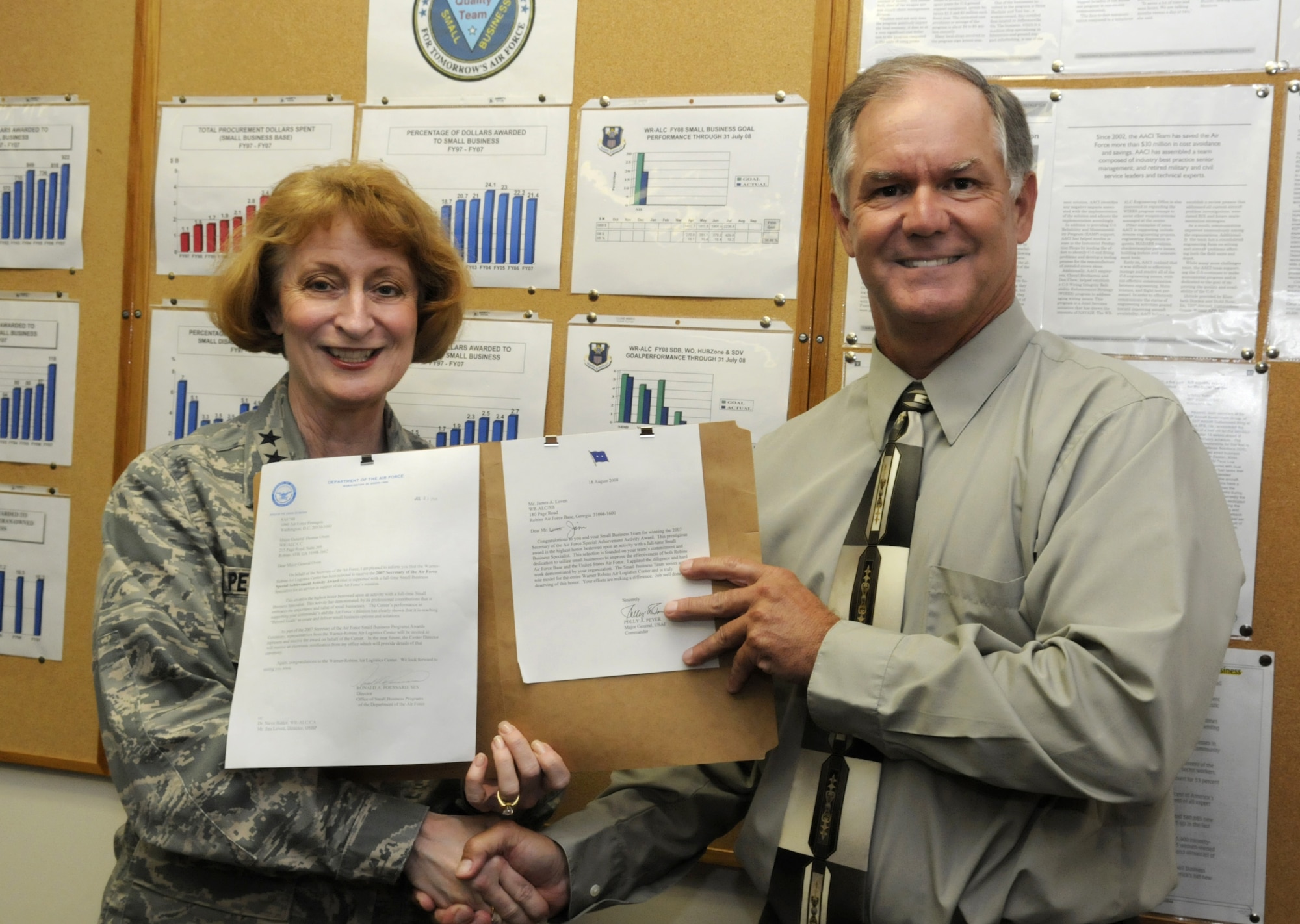 Maj. Gen. Polly Peyer presents Jim Lovett, WR/ALC office of small business programs director with a letter announcing an AF award to the Small Business Office during a surprise visit there Aug. 18. U. S. Air Force photo by Sue Sapp