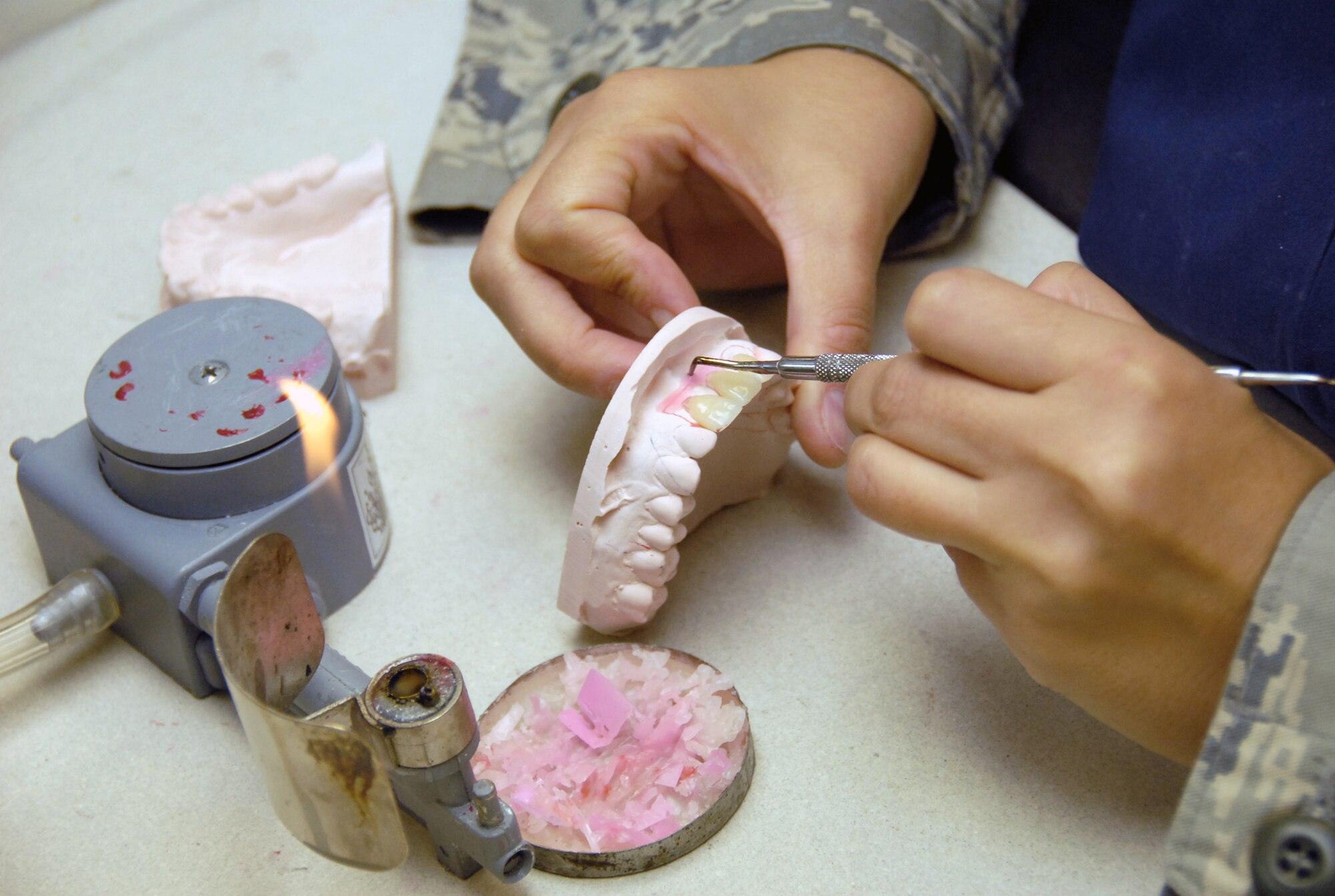 Staff Sgt. Andi Stevenson applies paint to a metal substructure to make a crown porcelain Aug. 19 at the area dental lab on Kadena Air Base, Japan. The area dental lab services 52  U.S. Pacific Command installations in Korea, Japan, Guam, Alaska and Navy ships at sea. Sergeant Stevenson is a dental lab technician at Kadena AB. (U.S. Air Force photo/Airman 1st Class Aaron Johnson)
