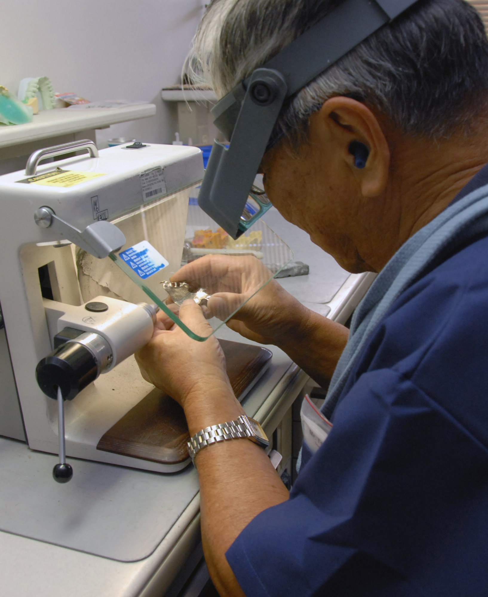 Tsunoda Warren, a dental lab technician with the 18th Dental Squadron's area dental lab, polishes a completed metal framework. Both the area dental lab and base dental lab produce a variety of dental prosthodontics including gold crowns, complete dentures, hard night guards, and soft or sport mouth guards and retainers. (U.S. Air Force photo/Airman 1st Class Aaron Johnson)