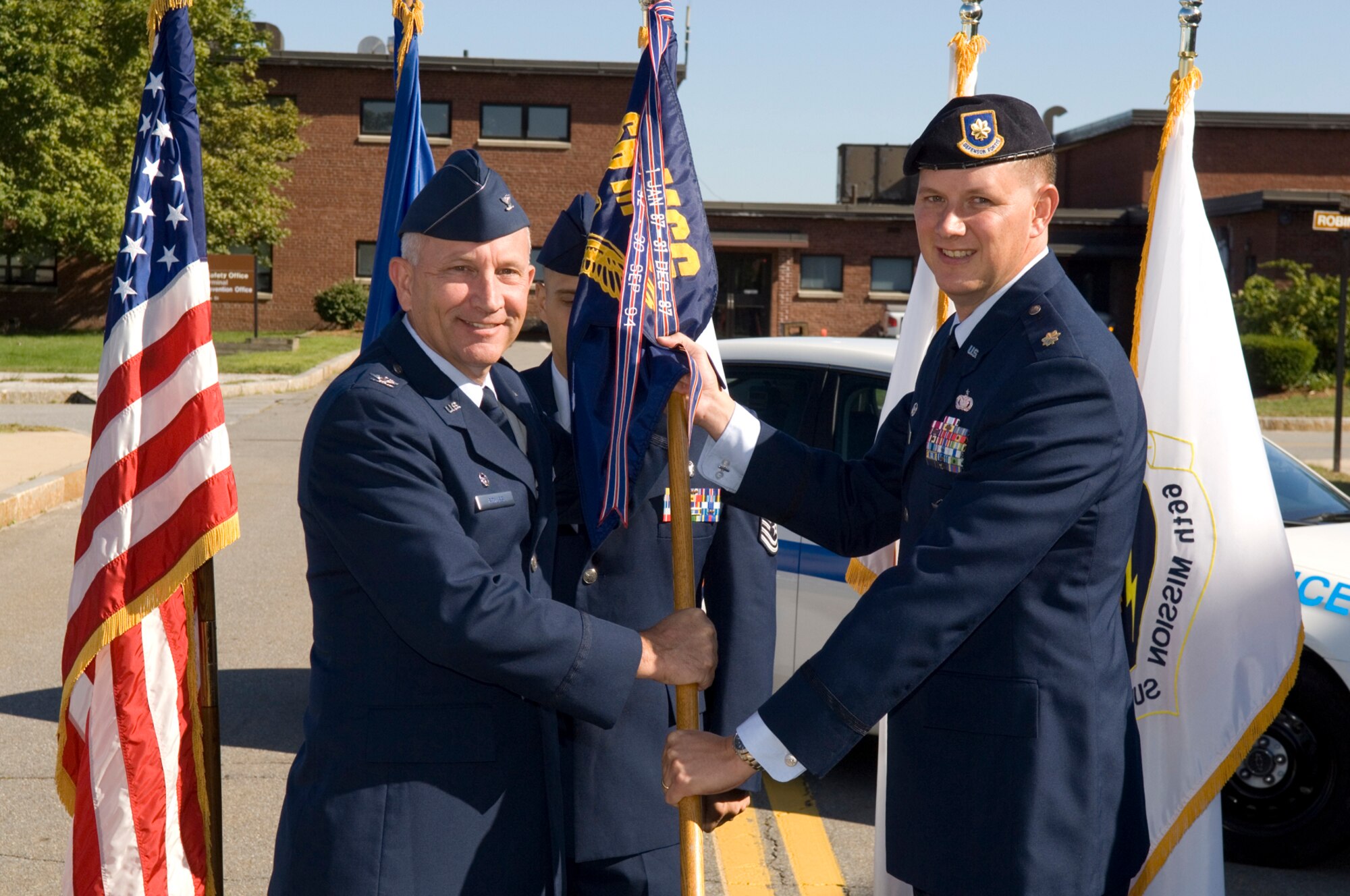 HANSCOM AFB, Mass. -- Col. Robert Boyles (left), 66th Mission Support Group commander, passes the 66th Security Forces Squadron flag to Maj. Christopher Echols during the squadron's change of command ceremony Aug. 27, in front of the Security Forces Building. Major Echols replaced Maj. Tamara Mayer. (U.S. Air Force photo by Rick Berry)
