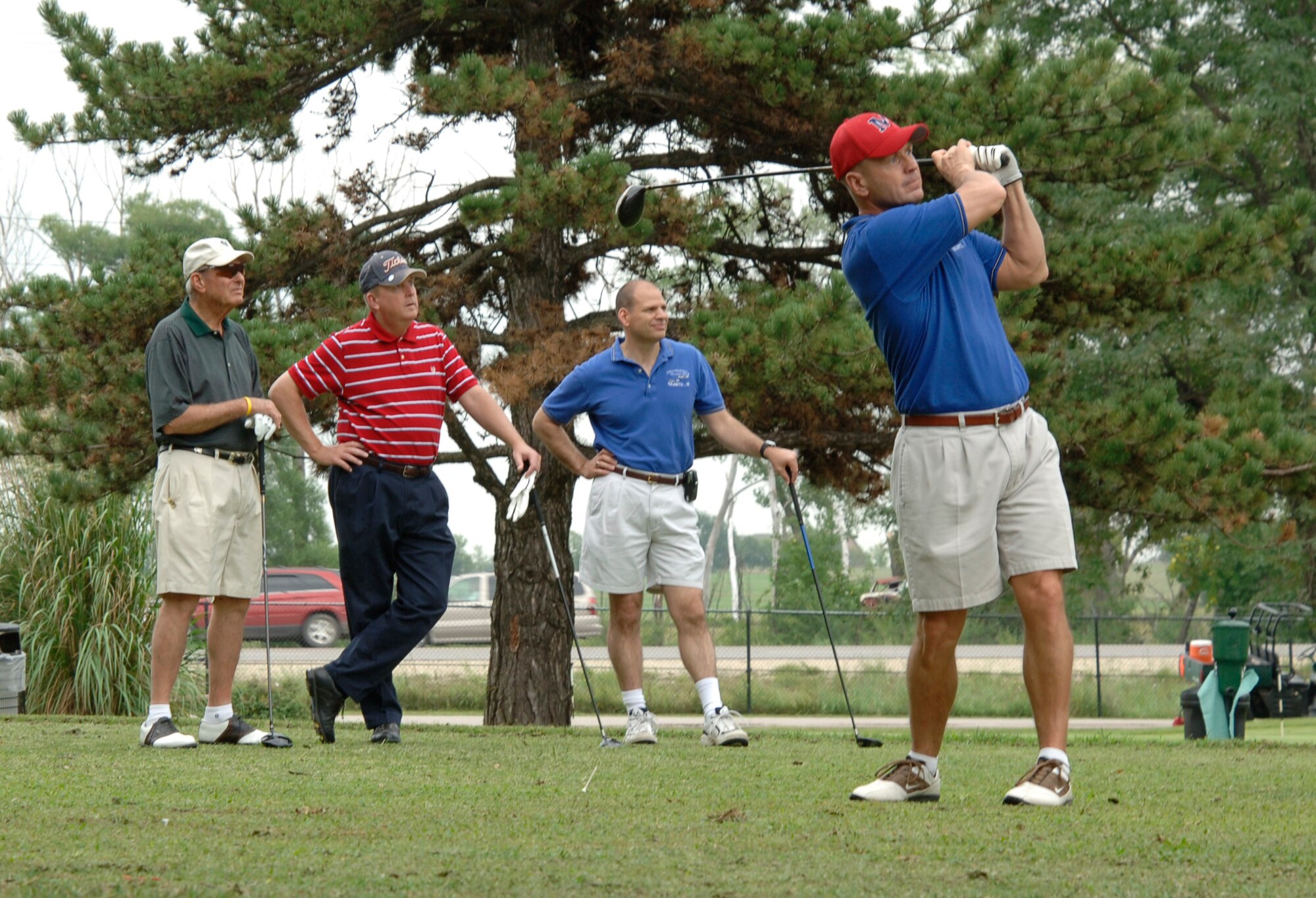 MCCONNELL AIR FORCE BASE, Kan. -- Jim Remsberg, Col. (ret) Dave Kramer and Col. James Vechery, 22nd Air Refueling Wing commander, watch while Chief Master Sgt. Michael Hedum, 22nd Air Refueling Wing command chief, tee’s off during a golf outing at Twin Lakes Golf Course, Aug. 21. The golf outing gave Team McConnell members a chance to socialize with local civic leaders. (Photo by Senior Airman Roy Lynch III)