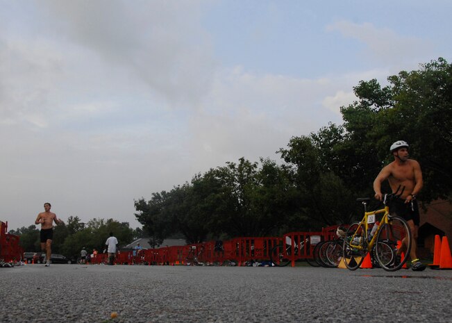 Triathlon participants rush toward the start line for the bicycling portion in the triathlon on Charleston AFB Aug. 23. Other events during the triathlon consisted of a 450 meter swim, 14,500 meter bicycling portion and a 5,000 meter run. The fitness center held the fifth annual triathlon to test people's fitness and allow a healthy extracurricular activity. (U.S. Air Force photo/Airman 1st Class Katie Gieratz)