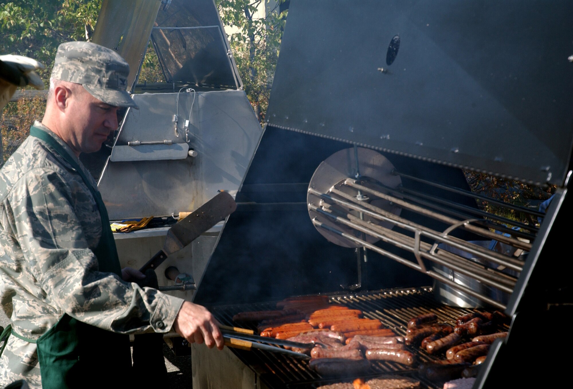 Col. Michael Jordan, 354th Fighter Wing vice commander, prepares food for a picnic outside Two Seasons Dining Facility on Eielson Air Force Base as part of Community Partnership Day Aug. 22, 2008. Community Partnership Day enhanced the base this year by planting trees and building new picnic tables. (U.S. Air Force photo/Airman 1st Class Willard E. Grande)