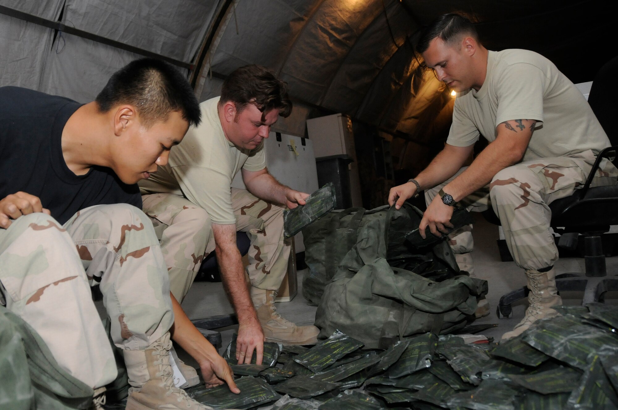 Airman 1st Class Sun Whang, left, Tech. Sgt. John Robinson, middle, and Staff Sgt. Dana Wiertalla, right, all expeditionary theater distribution center inventory team members assigned to the 379th Expeditionary Logistics Readiness Squadron, perform an inventory of M-295 decontamination kits Aug. 26, 2008, at an undisclosed air base in Southwest Asia. The 379th ELRS is responsible for ensuring all chemical protection bags are equipped with the right quantity and properly functioning equipment. Airman Whang is a native of Centreville, Va., Sergeant Wiertalla is a native of Grosse Pointe, Mich., and Sergeant Robinson is a native of Crisfield, MD. All are deployed from Nellis Air Force Base, Nev., in support of Operations Iraqi Freedom, Enduring Freedom and Joint Task Force-Horn of Africa. (U.S. Air Force photo by Staff Sgt. Darnell T. Cannady/Released)