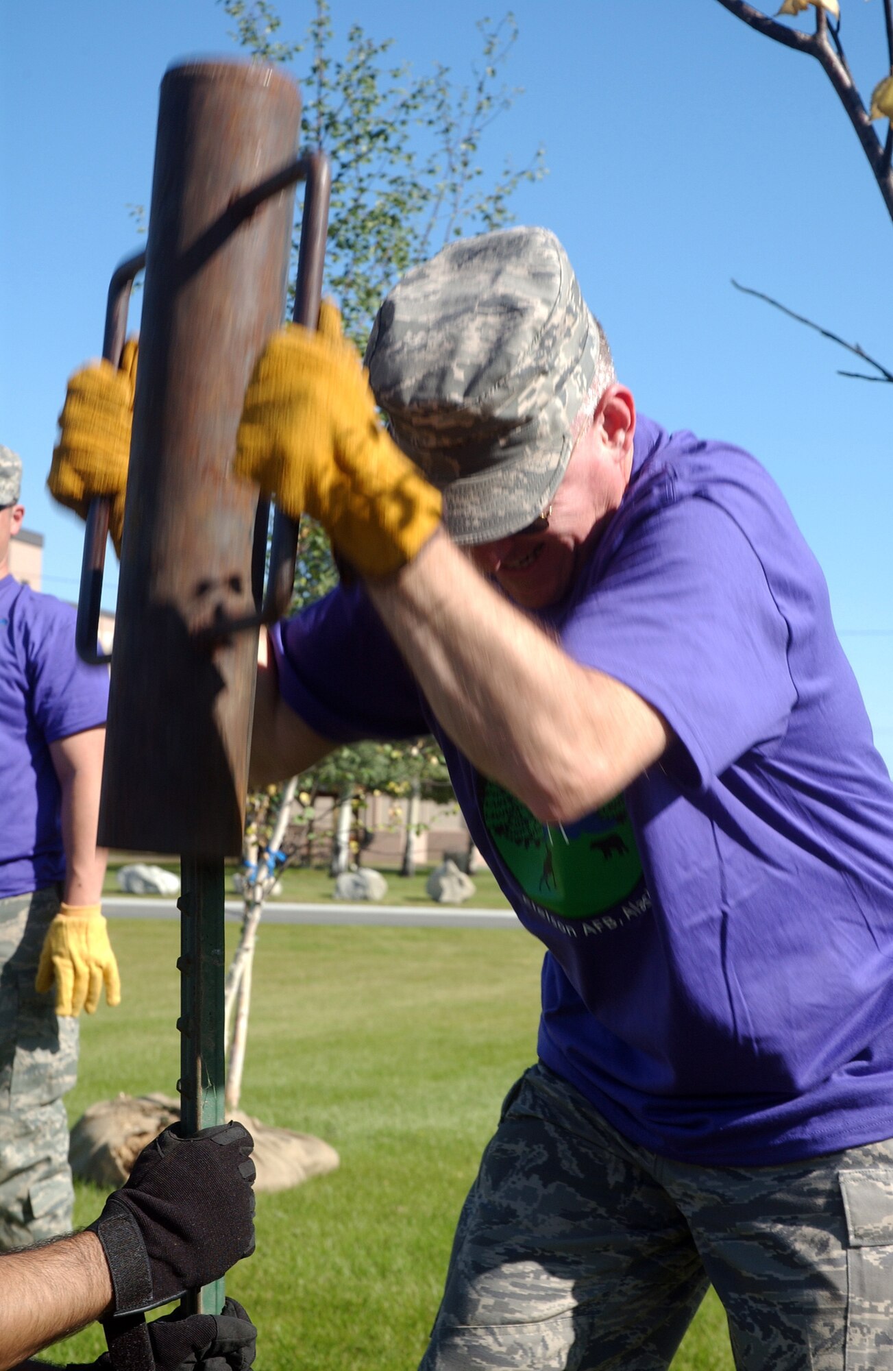 Chief Master Sergeant Earl Hannon, 354th Fighter Wing command cheif, drives support posts into the ground during Community Partnership Day Aug. 22, 2008. The posts keep newly planted trees vertical for optimal growth potential. (U.S. Air Force photo/Airman 1st Class Willard E. Grande II)