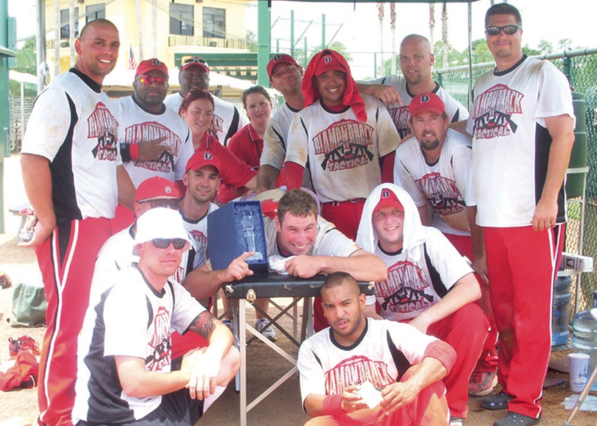 The Diamondback Tactics, a softball team comprised of all Andrews Air Force Base members, surround their injured pitcher holding the championship trophy, in celebration after their victory at the United States Specialty Sports Association’s Men’s Military World Tournament held in Orlando, Fla. Aug. 17.