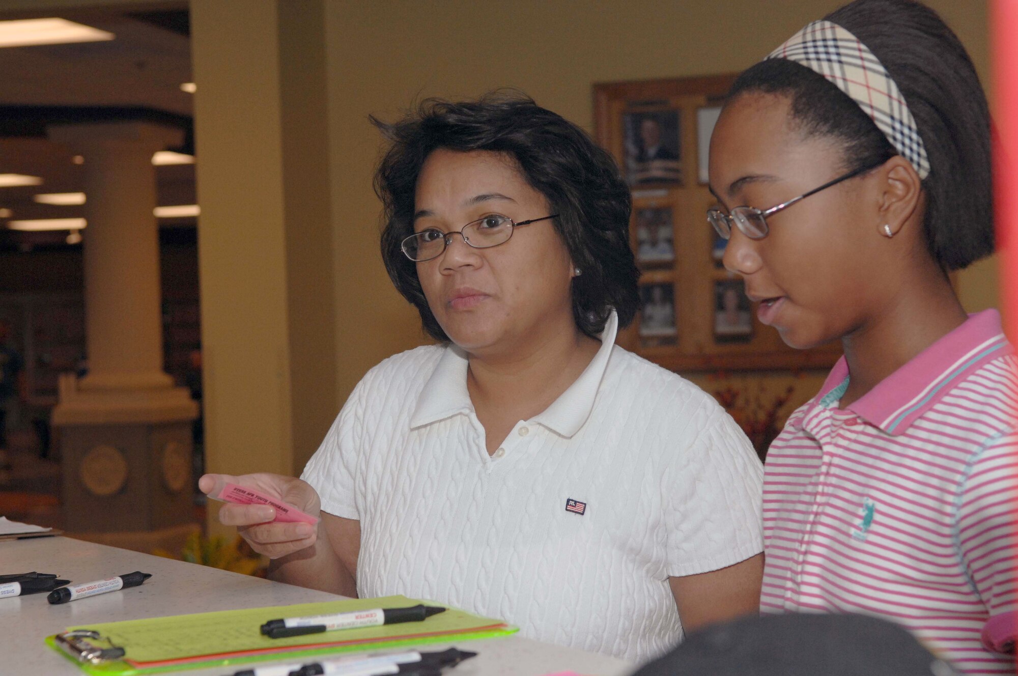 DYESS AIR FORCE BASE, Texas -- Mrs. Tip Womack and daughter Jessica, age 12, sign in to the new Youth Center on opening day here, Aug 19. The Youth Center is vital to the base allowing a safe place to keep Dyess kids active with sports, games, clubs and different other functions to be involved in.  (U.S. Air Force photo Staff Sergeant Connor Estes).      