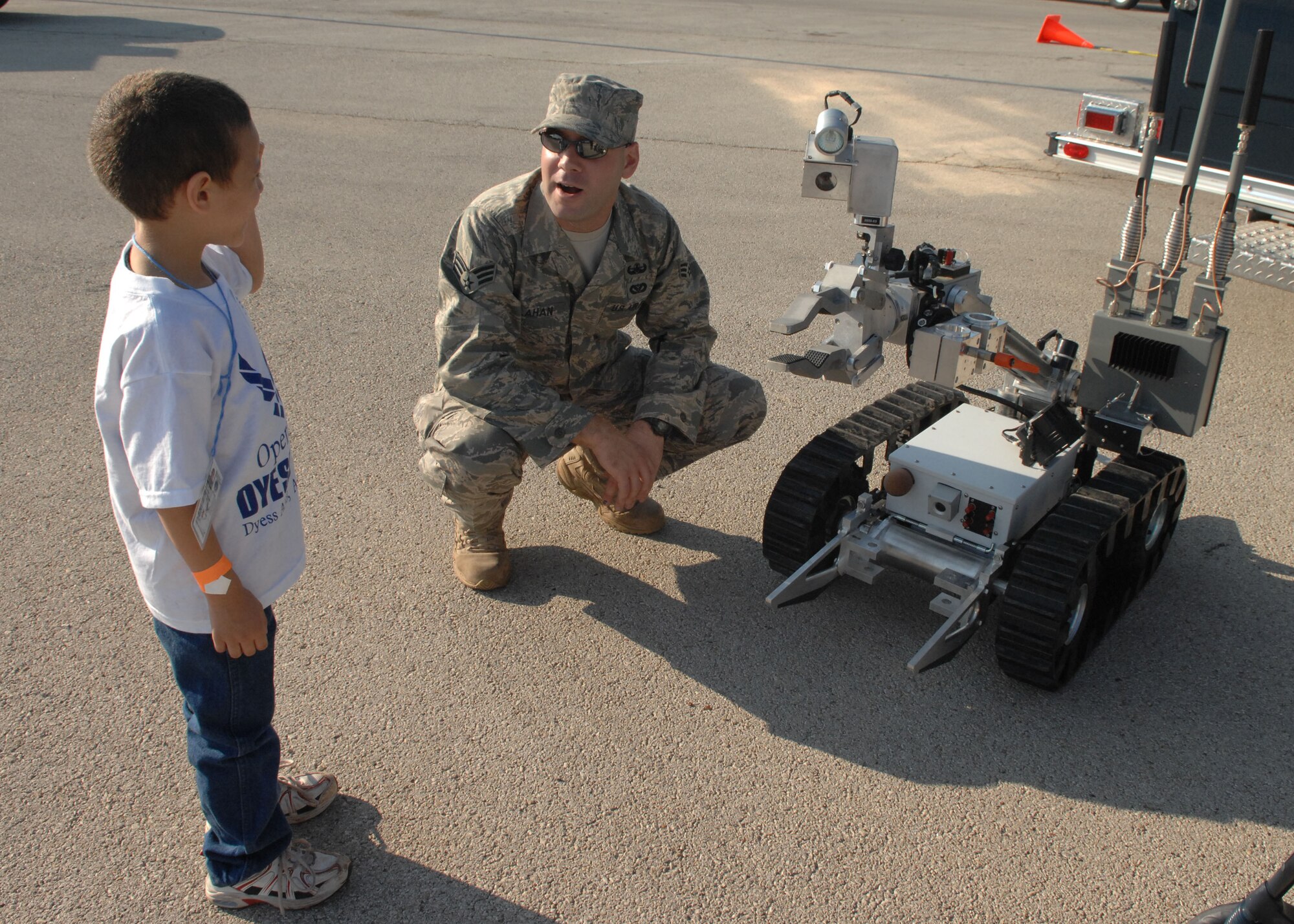DYESS AIR FORCE BASE, Texas -- Senior Airman Joel Calahan, 7th Civil Engineer Squadron explosive ordnance disposal specialist, shows 5 year old Alex Rivera, a military dependent, a robot used by the EOD flight to dismantle or explode bombs during Operation Dyess Kids here, Aug 22. Operation Dyess Kids is a program that helps dependents of military personnel understand the deployment process on the base.  (U.S. Air Force photo Staff Sergeant Connor Estes).     