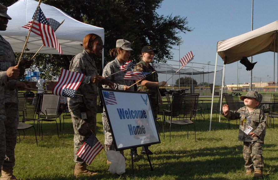 DYESS AIR FORCE BASE, Texas -- Jason Pillard, age 3, son of Staff Sergeant John Pillard, 317th Operations Support Squadron, waves to his welcome home party after returning from a long mock deployment during Operation Dyess Kids here, 22 Aug.  Operation Dyess Kids is a program that helps dependents of military personnel understand the deployment process on the base.  (U.S. Air Force photo Staff Sergeant Connor Estes).  