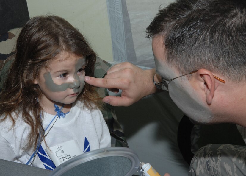 DYESS AIR FORCE BASE, Texas -- Sara Michael, a military dependent, gets her face painted by Technical Jesse Nichols, 7th Maintenance Operations Squadron, during Operation Dyess Kids here, 22 Aug.  Operation Dyess Kids is a program that helps dependents of military personnel understand the deployment process on the base.  (U.S. Air Force photo Staff Sergeant Connor Estes).     