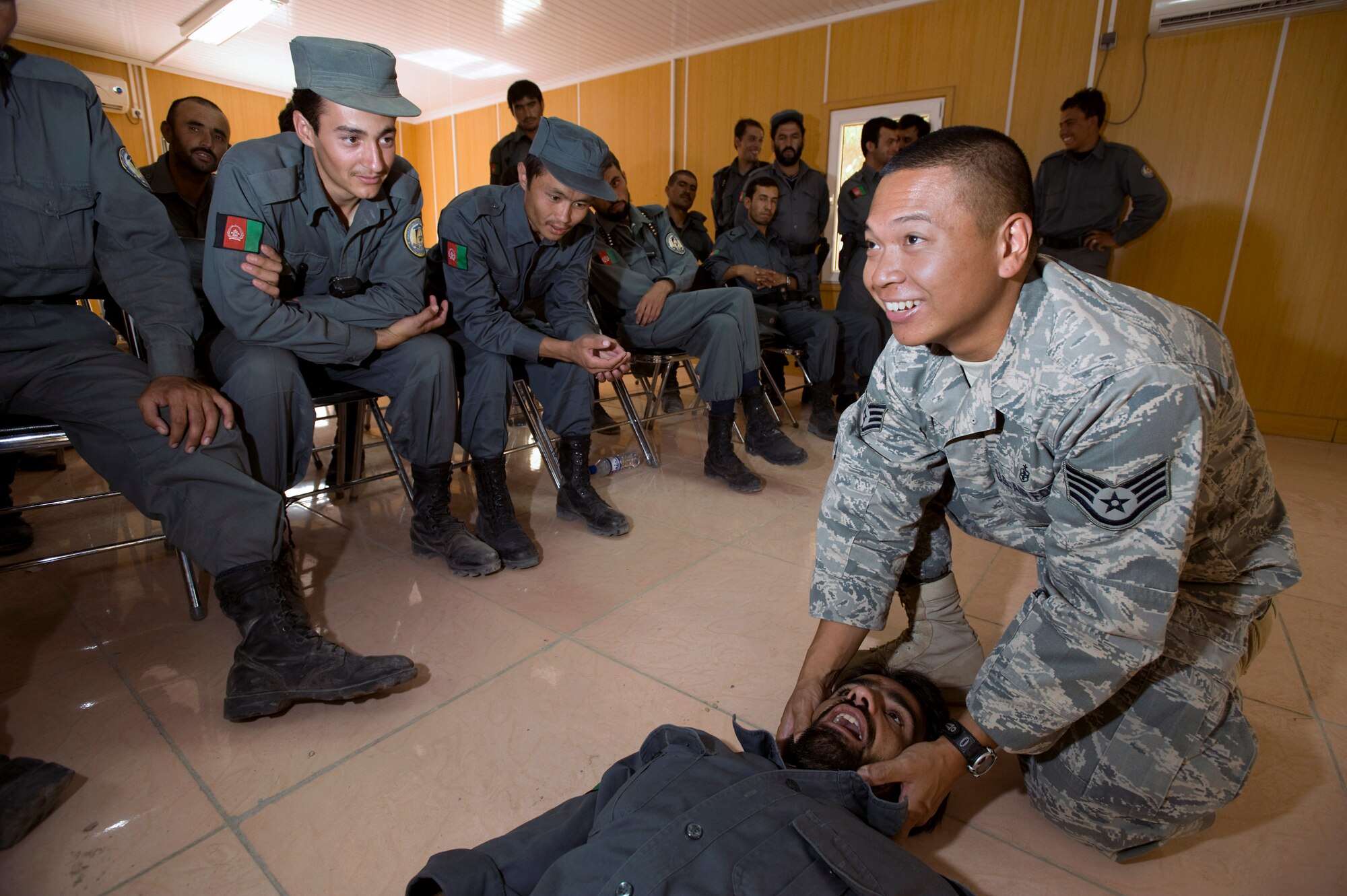 Staff Sgt. Nestor Albanos shows Afghan national police members how to open an airway during a Combat Life Savers course Aug. 12 at Qalat, Afghanistan. Sergeant Albanos is an Air Force medical technician assigned to the Zabul Provincial Reconstruction Team and teaches the ANP and other Afghan forces lifesaving skills at the PRT compound. (U.S. Air Force photo/Master Sgt. Keith Brown) 
