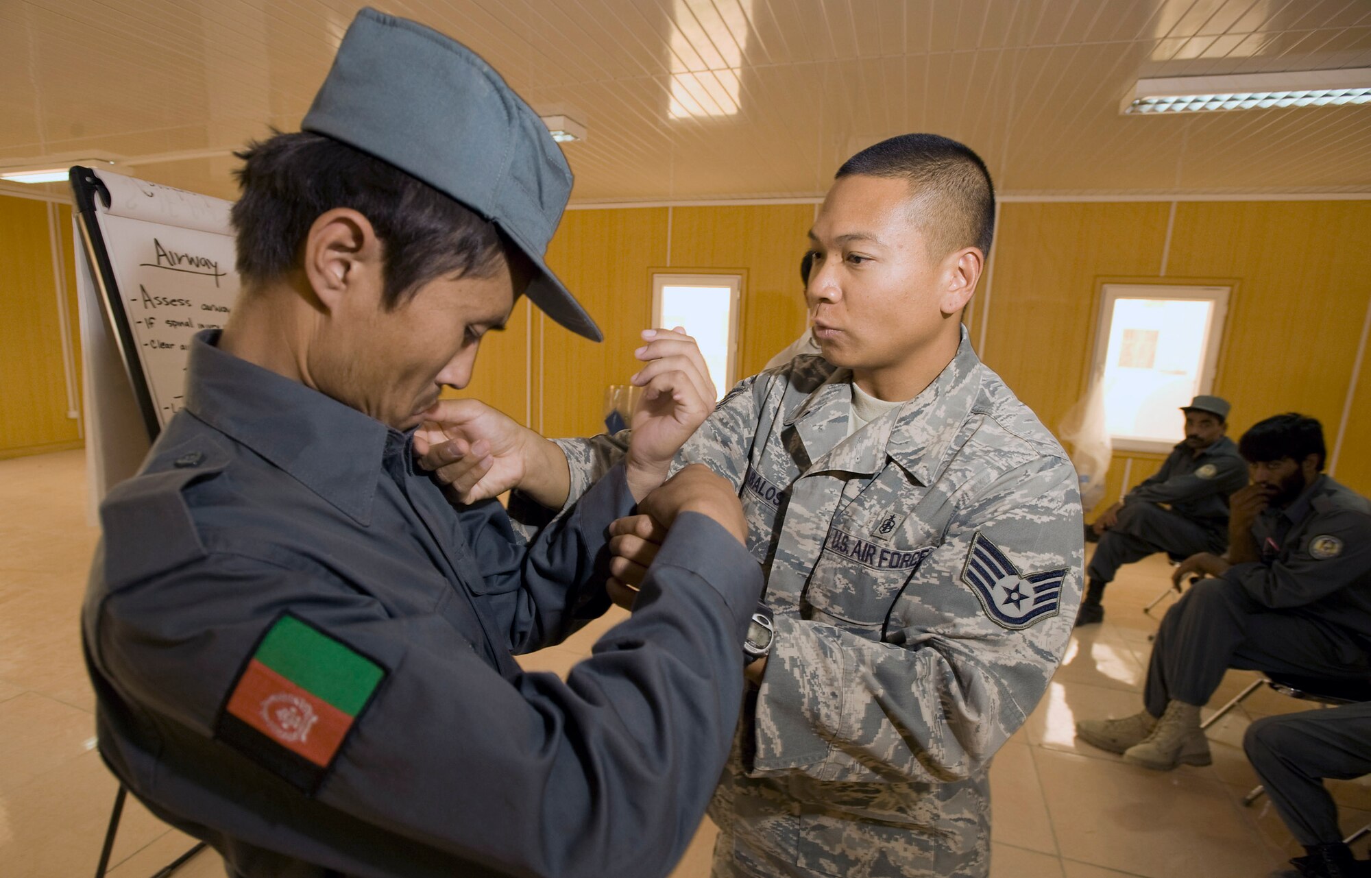 Staff Sgt. Nestor Albanos shows Afghan national police members how to make an impoverished sling during a Combat Life Savers course Aug. 12 at Qalat, Afghanistan. Sergeant Albanos is an Air Force medical technician assigned deployed to the Zabul Provincial Reconstruction Team and teaches the ANP and other Afghan forces lifesaving skills at the PRT compound. (U.S. Air Force photo/Master Sgt. Keith Brown) 

