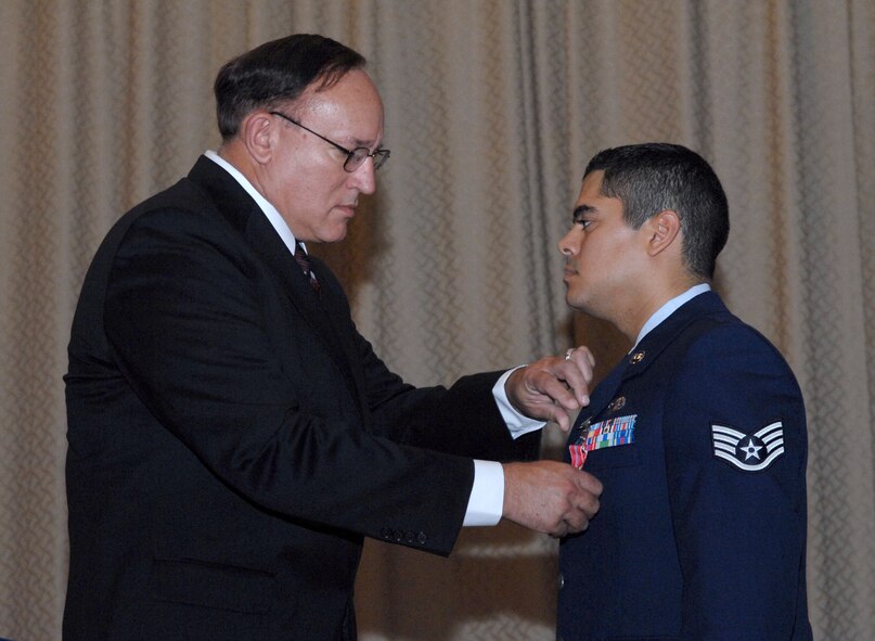 DYESS AIR FORCE BASE, Texas -- Staff Sergeant Yannick Sherenco, 7th Operation Support Squadron intelligence specialist, has the Bronze Star Medal pinned on by Captain (retired) Roderick Sherenco here, 21 Aug.  Sergeant Sherenco and two other Airmen received the prestigious medal for distinguishing themselves by exceptionally meritorious conduct in support of Operation Iraqi Freedom while working with the Army. (U.S. Air Force photo Staff Sergeant Connor Estes).   