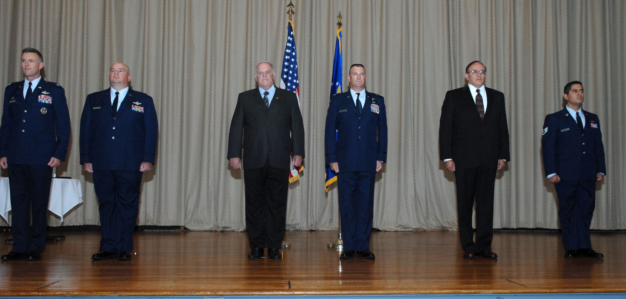 DYESS AIR FORCE BASE, Texas -- Bronze Star Medal recipients and their presenters stand at attention in the base theater during the reading of citations which accompanied the awards, 21 Aug.  The three Airmen received the prestigious medal for distinguishing themselves by exceptionally meritorious conduct in support of Operation Iraqi Freedom while working with the Army.  (U.S. Air Force photo Staff Sergeant Connor Estes).     