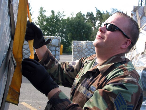 Staff Sgt. Jess Knutson tightens cargo straps on a pallet at the Joint Mobility Processing Center, Ramstein AB, Germany, Aug. 24.   More than 428 tons of relief supplies have been shipped to the Republic of Georgia since Aug. 13. Sergeant Knutson is an air transportation craftsman with the 435th Logistics Readiness Squadron. (U.S. Air Force photo/Staff Sgt. Jennifer Arredondo)