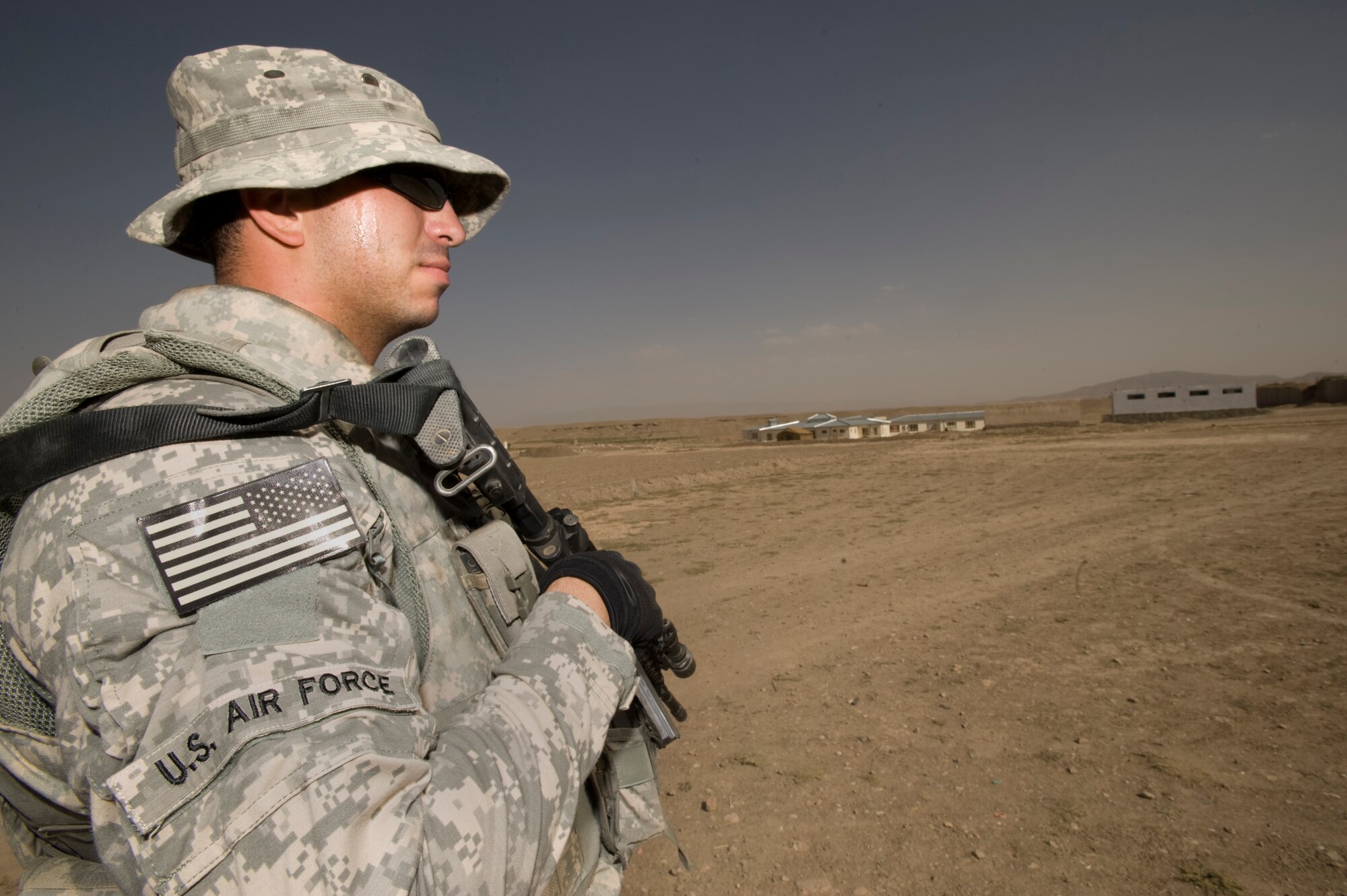 QALAT, Afghanistan -- Air Force Staff Sgt. Joe Montano provides security while other members of the Zabul Provincial Reconstruction Team survey construction progress made at a boys school here August 10th. Sergeant Montano, who is an F-15 crew chief at Nellis Air Force Base, Nev., is a MRAP (Mine Resistant Ambush Protected) vehicle driver and provides security for the team during his year long deployment here.  (U.S. Air Force Photo by Master Sgt. Keith Brown)