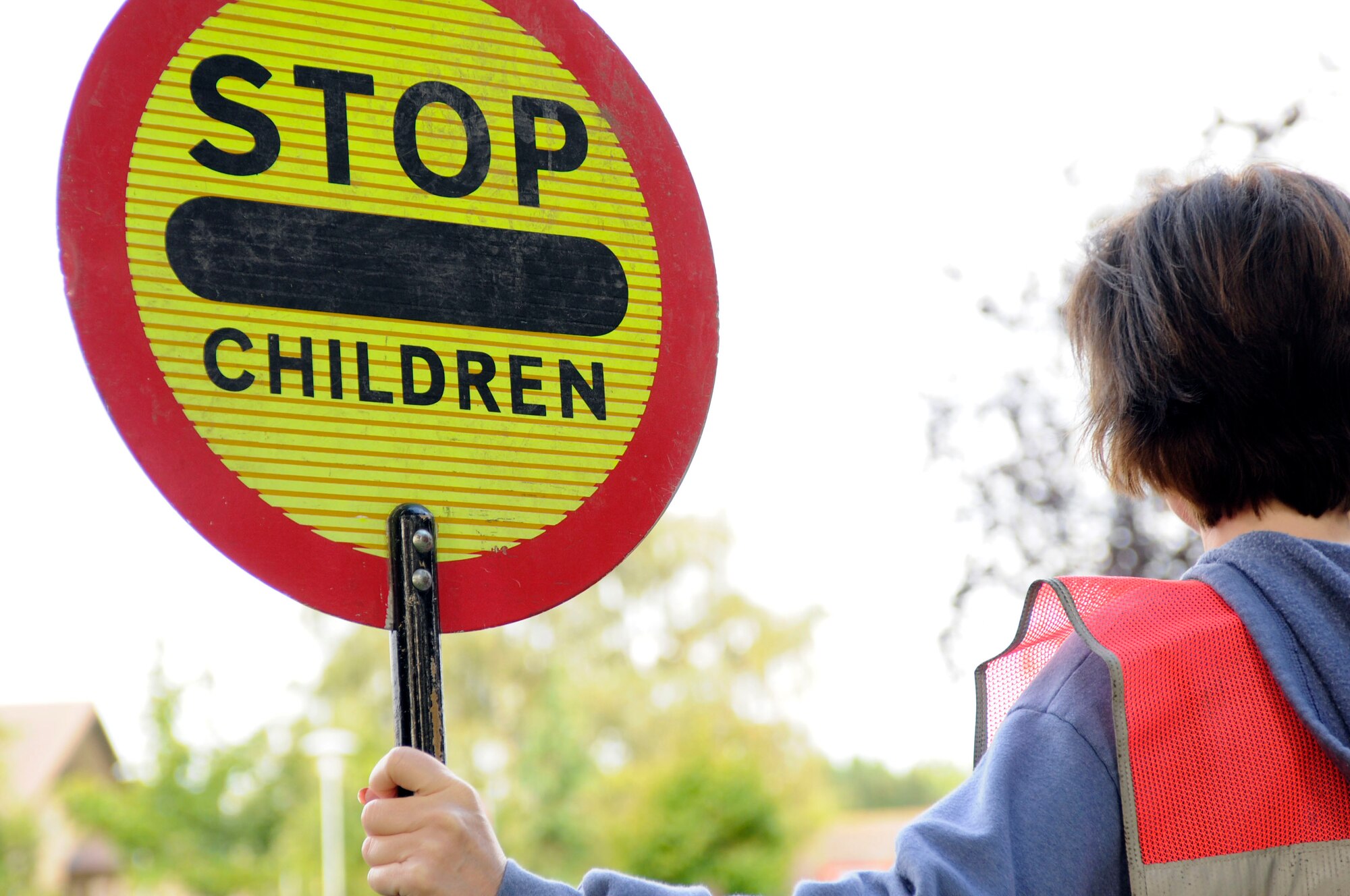 Master Sgt. Donna Hustad, 48th Fighter Wing ground safety NCO in charge, holds a traffic sign Aug. 25 as part of RAF Lakenheath's Volunteer Crosswalk Program. The purpose of the volunteer crosswalk program is to promote child safety amongst the base. (Air Force photo by Senior Airman Stacy Sanchez)