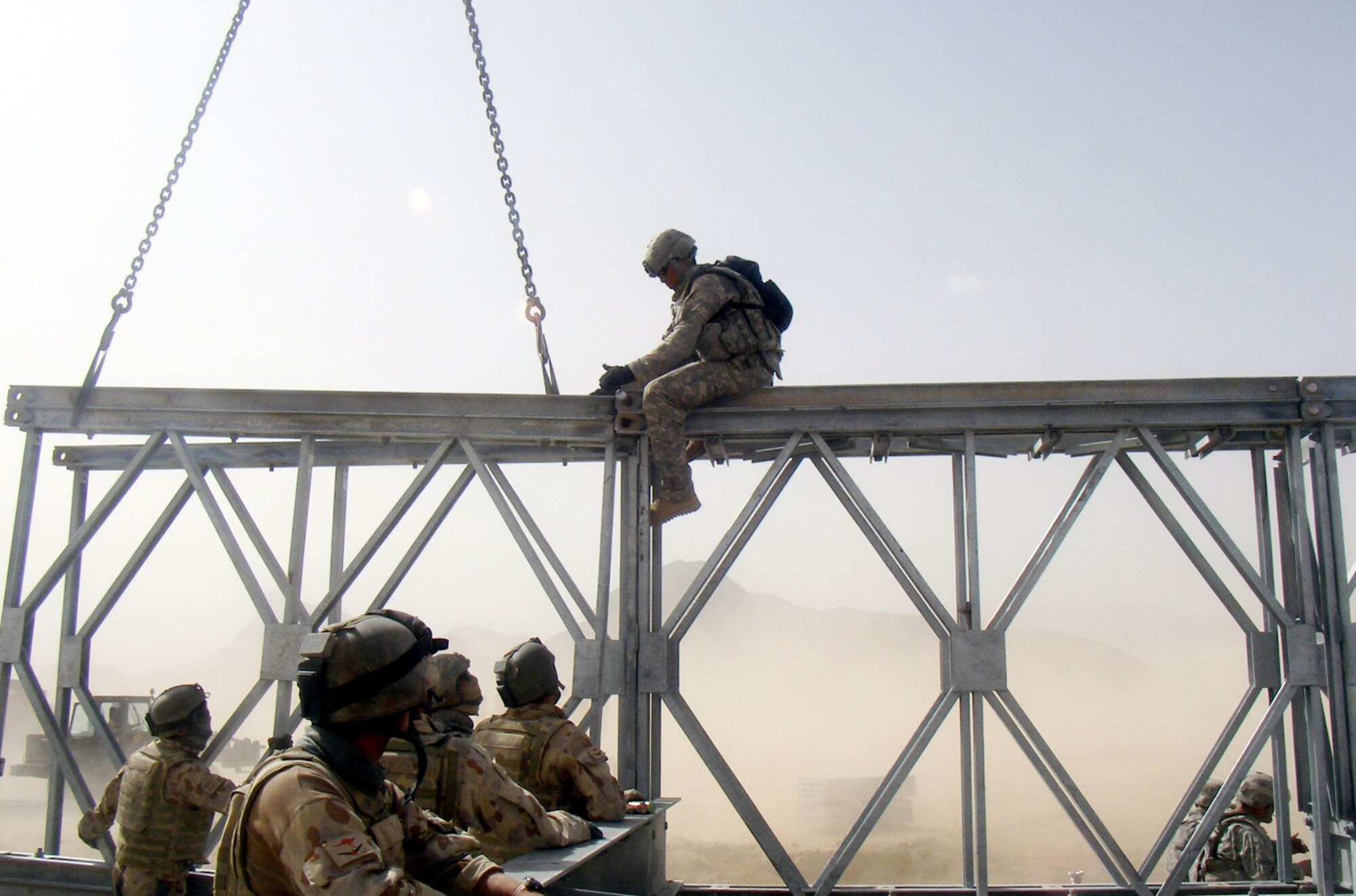 Spc. Corey Thompson, 420th Engineer Brigade, works with Australian Combat Engineers as they align two sections of the bridge. (U.S. Army photo/ Capt. James Reid)