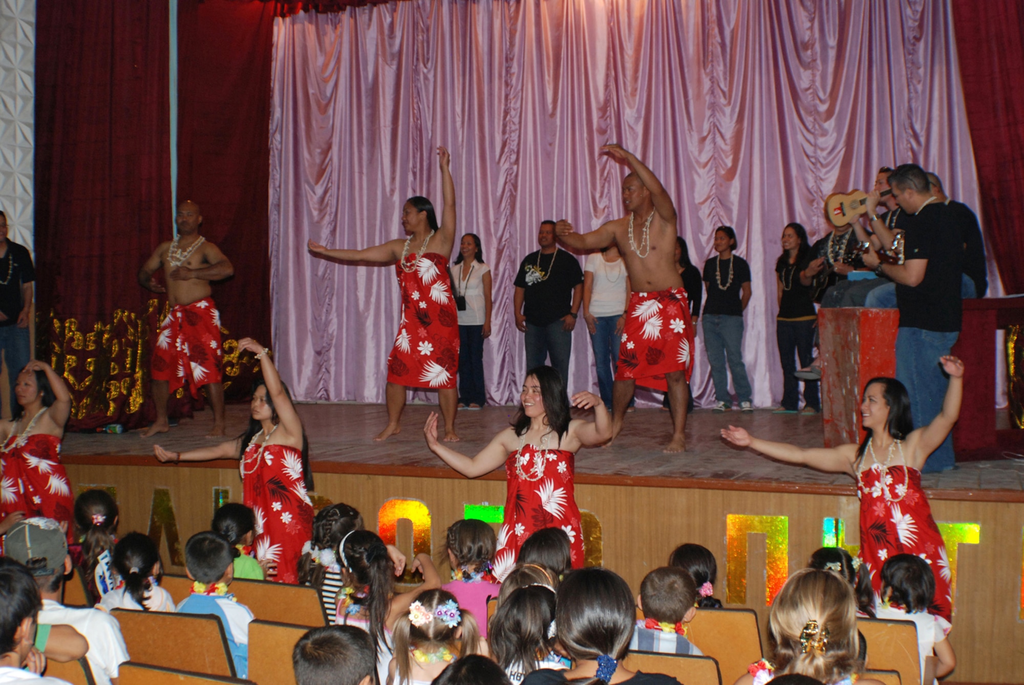 MANAS AIR BASE, KYRGYZ REPUBLIC -- Members of the 376th Air Expeditionary Force Support Squadron share traditional Pacific Island songs and dances with a group of more than 100 Kyrgyz children during the Pacific Island Cultural Day of Sharing in the village of Jeny Pahkta, Aug. 20. The 376th EFSS has sponsored the Kyrygz village for six years, donating clothes and painting and cleaning the local school. (Air Force photo / Senior Airman Alison Osborn)