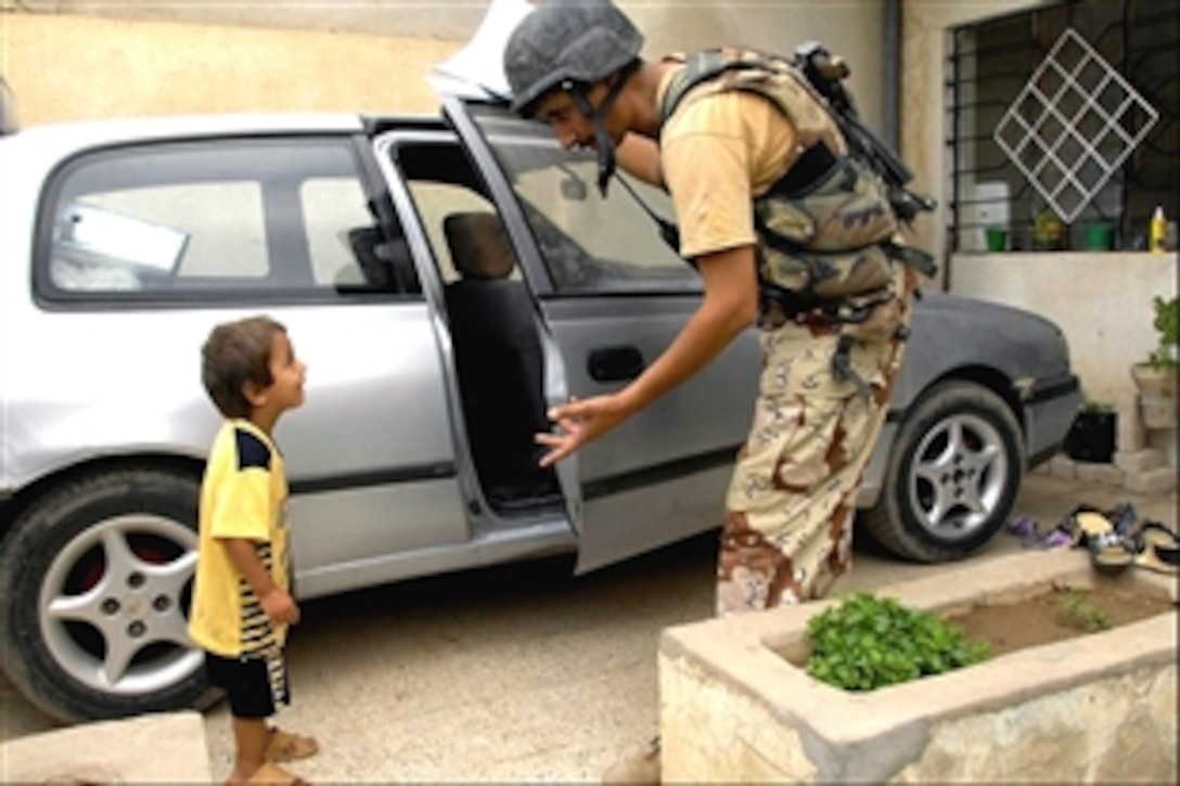 An Iraqi soldier makes friends with an Iraqi boy during a cordon and search in West Palestine, Mosul, Iraq, Aug. 23, 2008. The Iraqi soldiers are assigned to the 3rd Battalion, 5th Brigade, 2nd Division, Military Transition Team. 
   
