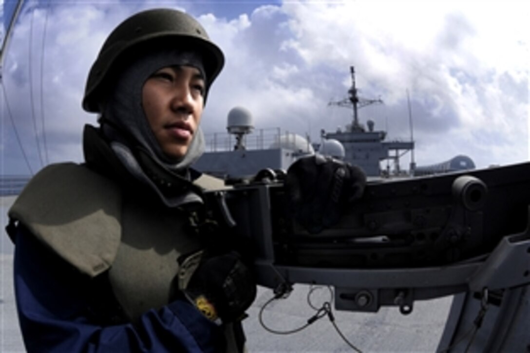 U.S. Navy Petty Officer 2nd Class Chris Noerjadi mans a .50-caliber machine gun and scans the horizon for enemy combatants during a general quarters drill aboard the amphibious command ship USS Blue Ridge in the Pacific Ocean, Aug. 26, 2008. Blue Ridge serves under Commander, Expeditionary Strike Group 7/Task Force 76, the Navy's only forward deployed amphibious force. 