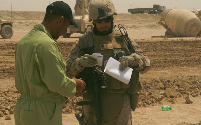 FALLUJAH, Iraq (September 2, 2008) – Staff Sgt. Aaron Colling (right), team chief, Civil Affairs Team 2, talks to an Iraqi contractor during a project assessment here, Aug. 26. Civil Affairs Team 2, 2nd Battalion, 11th Marines, in direct support of 3rd Battalion, 6th Marines, and the Fallujah City Council are three weeks into repaving the route through Entry Control Point 1A (ECP1A), a checkpoint on the outskirts of Fallujah designed to safeguard the commercial truck entrance into the city. (Official U.S. Marine Corps photo by Cpl. Chris Lyttle) (RELEASED)