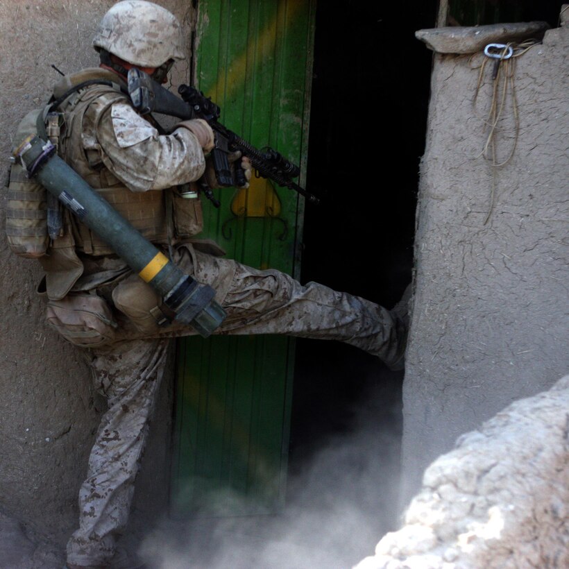 Sergeant David J. Lang, a combat engineer assigned to Company F, Task Force 2d Battalion, 7th Marine Regiment, 1st Marine Division, and a Port Orchard, Wash., native, kicks a door in to clear a room during an assault on a Taliban-held compound, Aug. 28. (U.S. Marine Corps photo by Cpl. James M. Mercure)