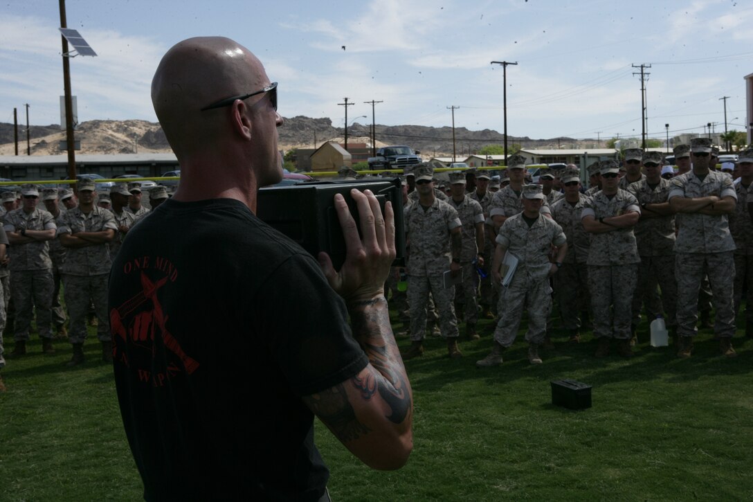 Sgt. Patrick Kaiser, instructor-trainer at the Martial Arts Center of Excellence, Quantico, Va., demonstrates the ammunition can lift during the Marine Corps Training and Education Command’s Fitness Roadshow at the Combat Center Aug. 28.