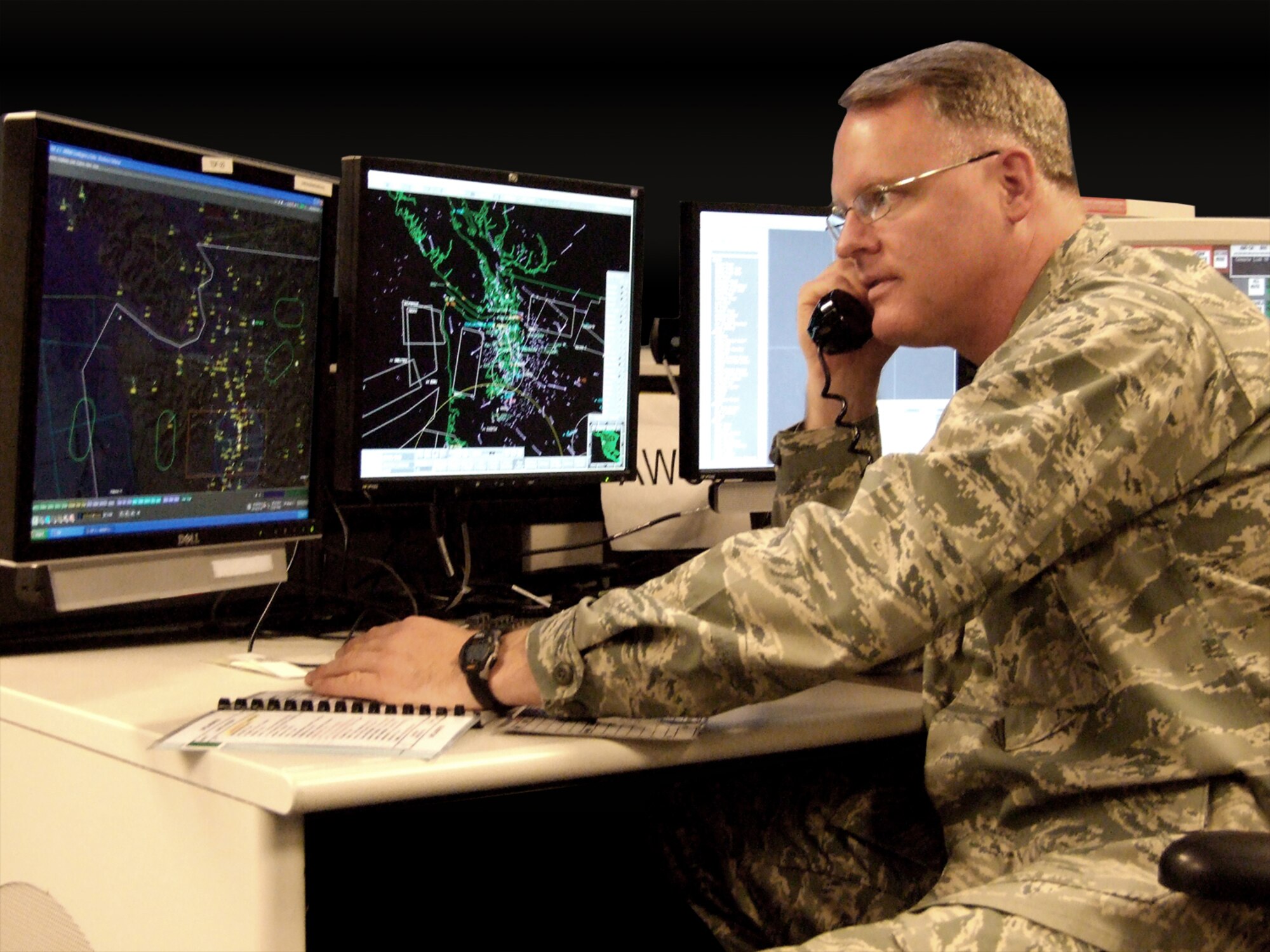 Lt. Col. William Krueger, a mission crew commander at WADS, works a call similar to he one he received when helping Harlon Hain through the clouds Aug. 12.  Krueger and his crew used raw radar data to fix Hain's position and assisted FAA in vectoring an EA-6B Prowler to him.  (U.S. Air Force photo by Vivian Wilson) 