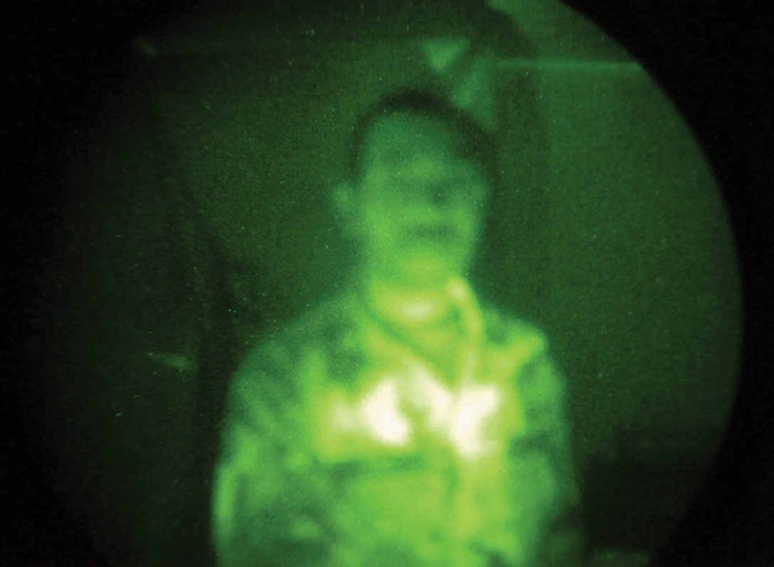 An aircrew member views an infrared image of Tech. Sgt. Marcus Reed, 1st Helicopter Squadron Aircrew Flight Equipment assistant NCO in charge, during a nightvision goggle test. Aircrew use nightvision goggles to help see dark landing zones and terrain features.