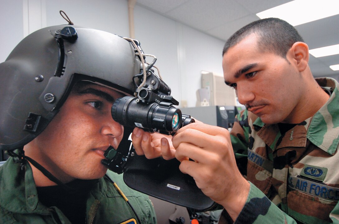 Senior Airman Ricardo Martin, 1st Helicopter Squadron aircrew flight equipment technician, makes adjustments on a pair of night vision goggles for Staff Sgt. Justin Shults, 1HS flightengineer, prior to an upcoming mission.