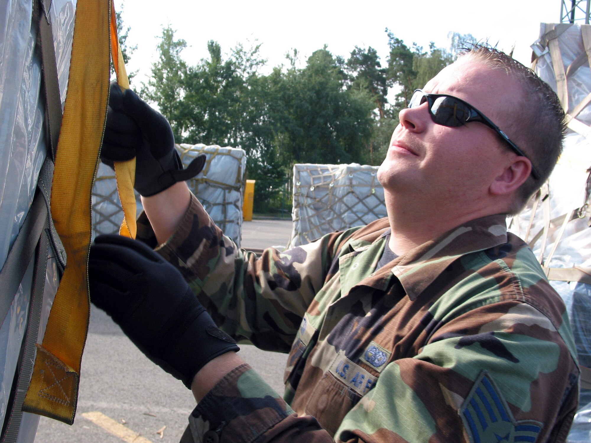 Staff Sgt. Jess Knutson tightens cargo straps on a pallet Aug. 24 at the Joint Mobility Processing Center at Ramstein Air Base, Germany, Aug. 24.   More than 428 tons of relief supplies have been shipped to the Republic of Georgia since Aug. 13. Sergeant Knutson is an air transportation craftsman with the 435th Logistics Readiness Squadron. (U.S. Air Force photo/Staff Sgt. Jennifer Arredondo)