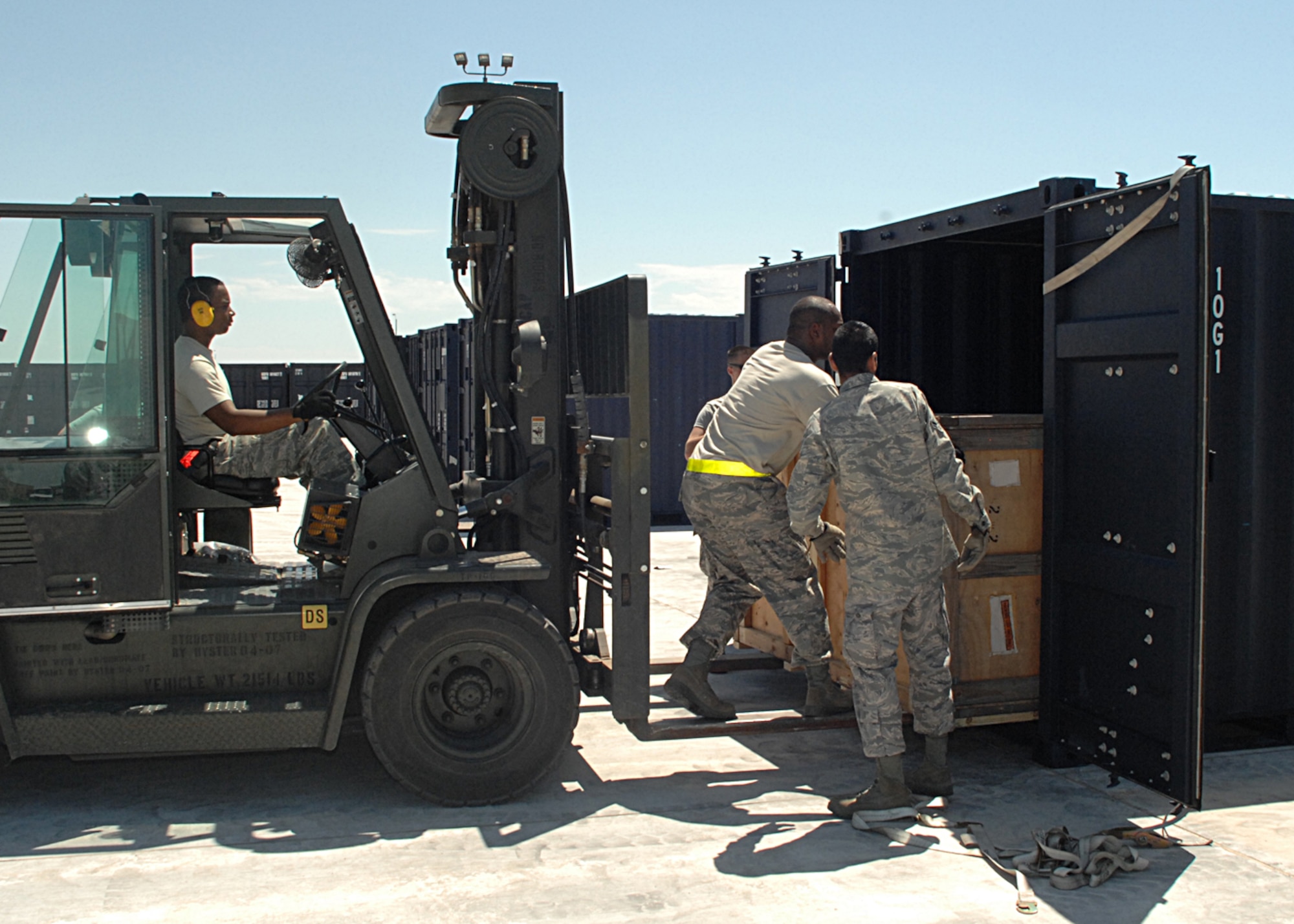 Staff Sgt. Nathaniel Jackson and Airman 1st Class Jorge Ontiveros, both from the 49th Materiel Maintenance Support Squadron, help unload cargo from a forklift as Staff Sgt. Roland Vigne, also from the 49th MMSS, guides it in. (U.S. Air Force photo/Staff Sgt. Terri Barriere)