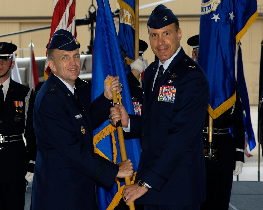 ANDREWS AIR FORCE BASE, Md. -- Maj. Gen. Ralph Jodice, Air Force District of Washington commander, passes the 316th Wing guidon to Col. Steven Shepro on Aug. 28 in Hangar 1 during the Assumption of Command ceremony. Colonel Shepro comes from Balad Air Base, Iraq where he served as vice commader of the 332nd Air Expeditionary Wing.