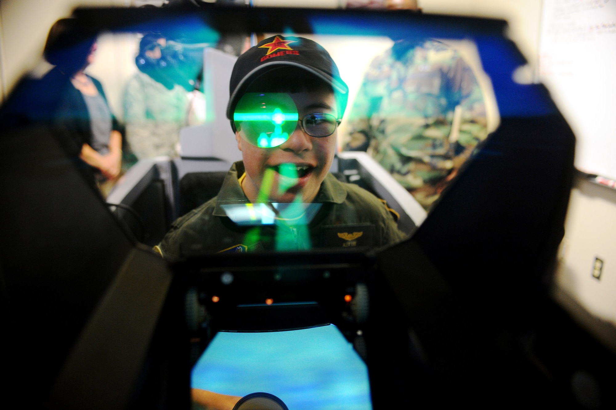 Alex Lee looks through an F-16 Fighting Falcon simulator head-up display during a simulated mission Aug. 22 at Eielson Air Force Base, Alaska. Alex was born with congenital heart defects and Down syndrome and was selected by the Make-A-Wish Foundation for the Pilot for a Day program. The purpose of the program is to ease the pain of children who lost a normal childhood due to illnesses or disabilities. (U.S. Air Force photo/Airman 1st Class Jonathan Snyder) 
