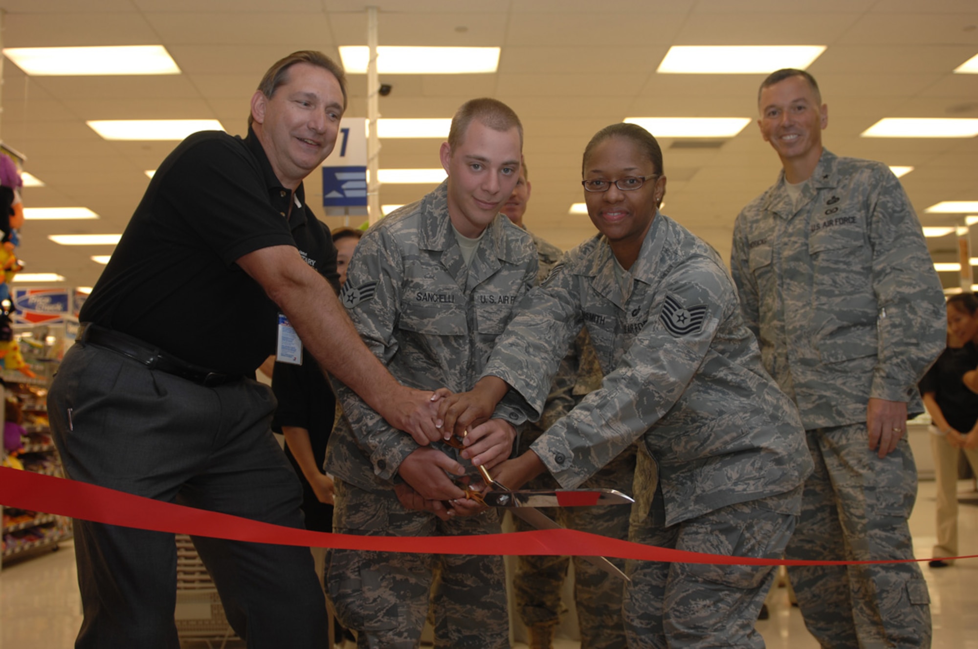 (Left to right) Andy Louder, Ellsworth Base Exchange manager, Senior Airman Anthony Sanchelli, 28th Bomb Wing protocol specialist, and Tech. Sgt. Laquisha Highsmith, Air Force Financial Services Center merged accountability and fund reporting section chief, cut the ribbon at the revamped BX here as Brig. Gen. Francis Hendricks, Army and Air Force Exchange Services deputy commander, watches, Aug. 28. This event marked the BX's grand reopening after installing all-new floors and relocating store departments such as military clothing. (U.S. Air Force photo/Airman 1st Class Joshua J. Seybert)