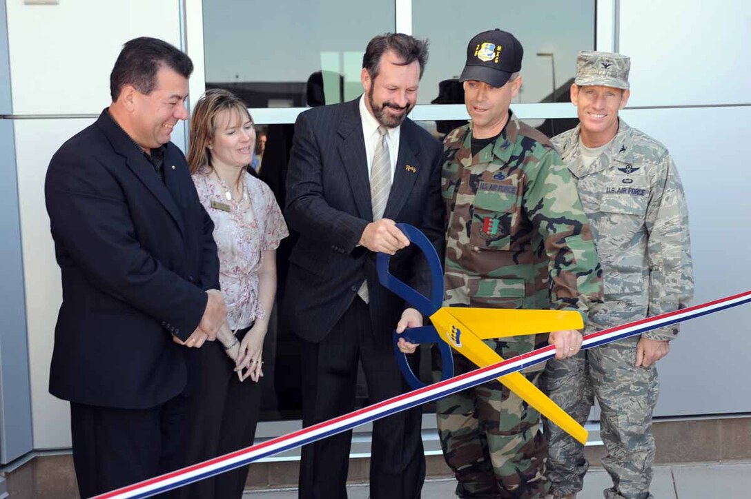 (Center) Alan Hanks, Rapid City mayor, cuts the ribbon for the new 28th Maintenance Group Headquarters building while accompanied by (immediate right) Col. Fitch, 28th Maintenance Group commander, Col. Peter Castor, 28th Bomb Wing vice commander (far left) Mr. Qusi Al’Haj, representative for Sen. John Thune, Ms. Tania Schepper, representative for Congresswoman Stephanie Herseth-Sandlin here Aug. 28. The 28th Maintenance Group,  manages the production of a 1,400-member workforce comprised of four squadrons, an annual organizational maintenance and reparable support division budget exceeding $42.5 million, aircraft and weapons valued at more than $9 billion, and real property worth $168 million. (U.S. Air Force photo/Airman 1st Class Adam Grant) 
