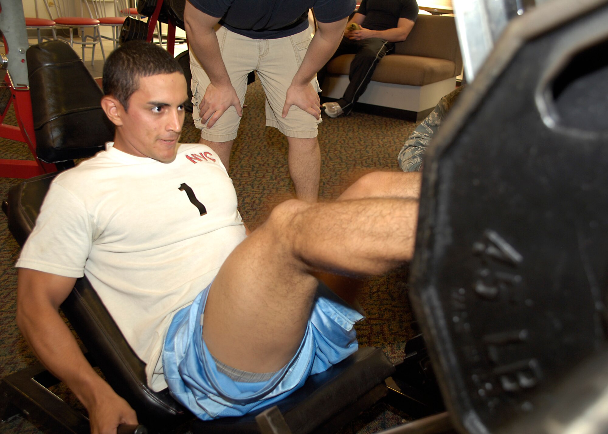 Team Holloman members look on as Airman 1st Class Emmanuel Rodriguez, 49th Medical Group, competes in the leg press portion the Iron Airman Challenge at Holloman Air Force Base, N.M., Aug. 27. Airman Rodriguez completed 111 leg press repetitions of 270 pounds during the competition. (U.S. Air Force photo/ Senior Airman Tiffany Trojca) (U.S. Air Force photo/ Senior Airman Tiffany Trojca)