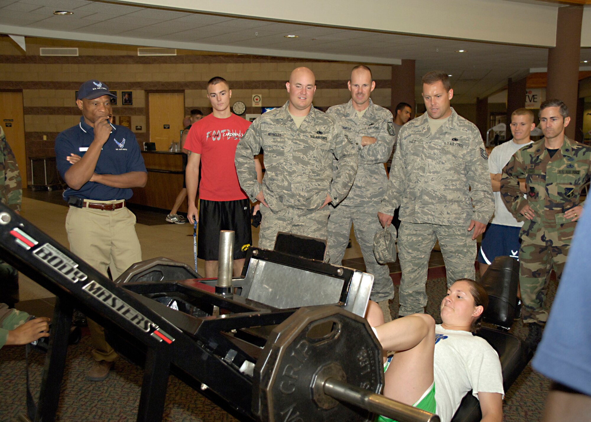 Team Holloman members look on as Staff Sgt. Sara Rosner, 49th Aircraft Maintenance Squadron, competes in the leg press portion the Iron Airman Challenge at Holloman Air Force Base, N.M., Aug. 27. Sergeant Rosner completed 46 leg press repetitions of 225 pounds during the competition. (U.S. Air Force photo/ Senior Airman Tiffany Trojca)