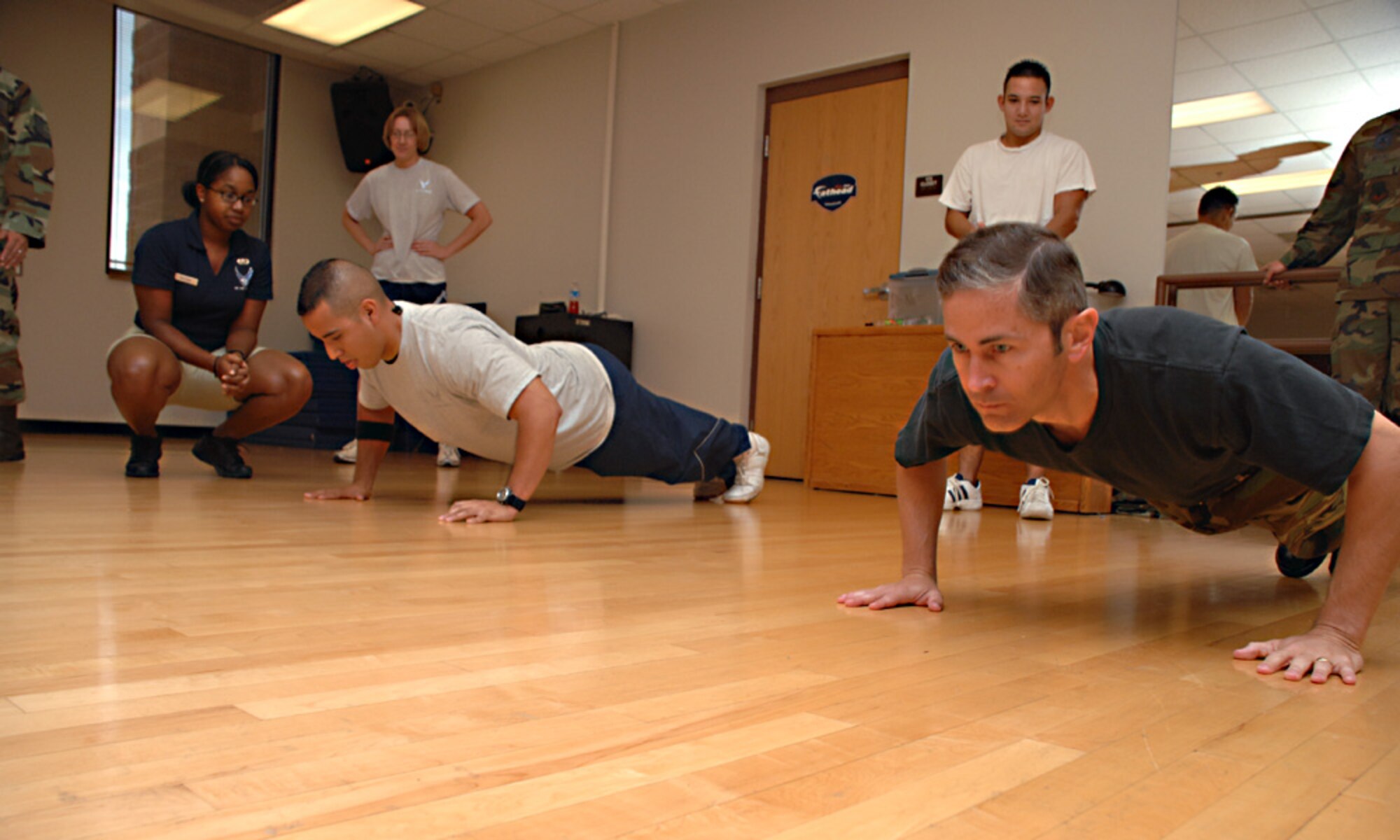 Senior Airman Jacob Rangel, 49th Medical Support Squadron, and Lt. Col. Steven James, 49th Aircraft Maintanance Squadron commander, compete during the push up portion of The Iron-Airman Challenge at Holloman Air Force Base, N.M., Aug 26. The Iron-Airman competition awards the team with the best physical fitness with a trophy. (U.S. Air Force photo/ Senior Airman Tiffany Trojca)