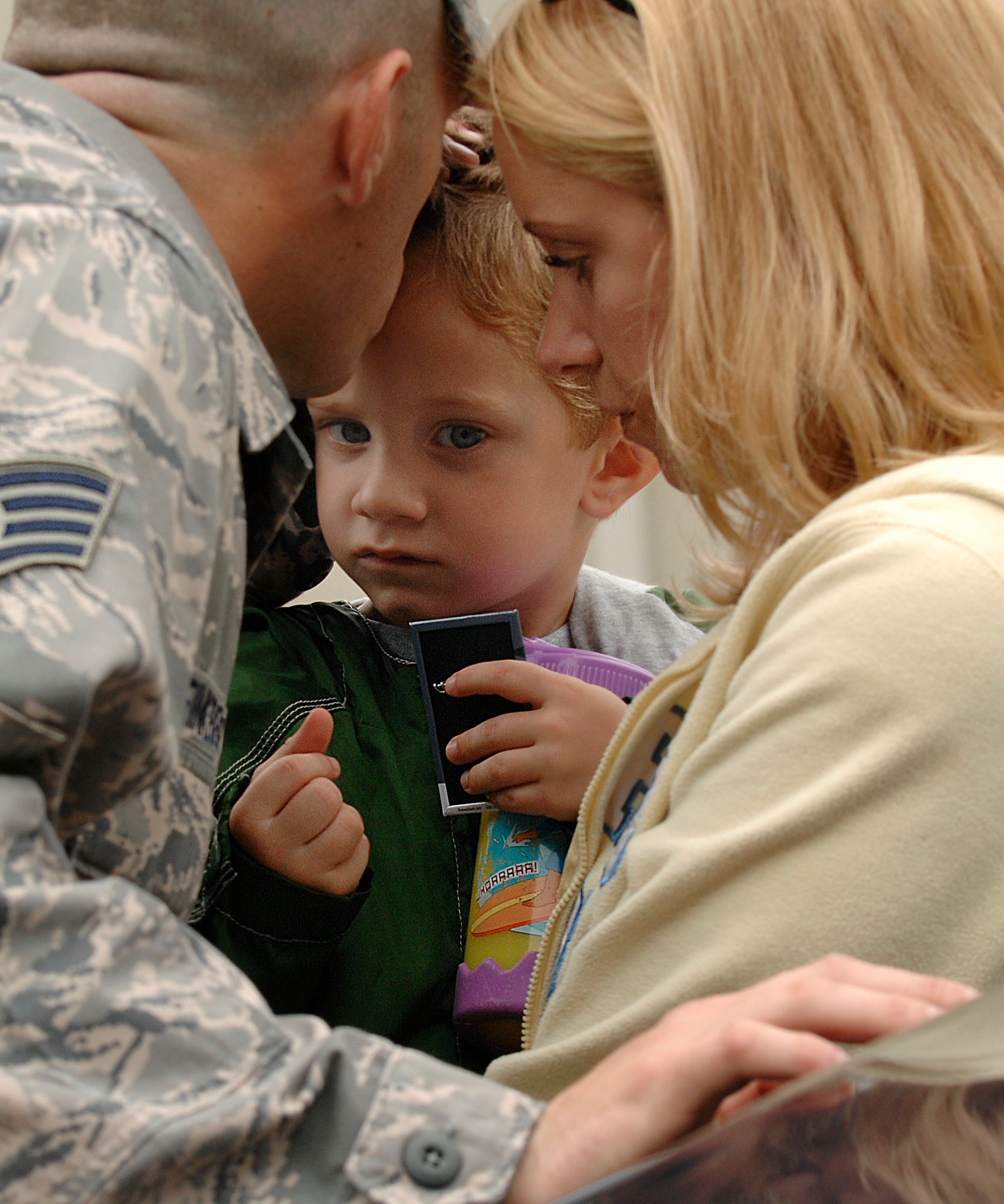 LANGLEY AIR FORCE BASE, Va. -- Staff Sgt. Joshua Finkbeiner, 1st Security Forces Squadron patrolman, kisses his son Caleb as he hugs his wife Amanda before leaving for a six-month deployment to Joint Balad Air Base, Iraq, Aug. 28.  This is Sergeant Finkbeiner's second deployment in support of the Global War on Terrorism.  
The 13-man team from the 1st SFS is tasked along with 800 Airmen Air Force-wide to relieve Army Soldiers from entry control point and tower patrol duties at Joint Base  Balad.  (U.S. Air Force photo/Senior Airman Vernon Young)