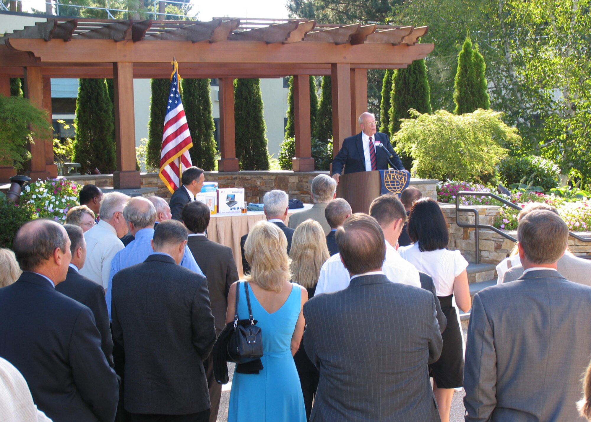 BEDFORD, Mass. ? Military and civilian members of the Lexington-Concord chapter for the Armed Forces Communications and Electronics Association listen to Kent Schneider, president and chief executive officer of AFCEA International, discuss the importance of fostering professional relationships among government agencies, the military and industry during the private organization?s yearly social, Aug. 27. AFCEA is a non-profit international association. (U.S Air Force photo by J.C. Corcoran)
