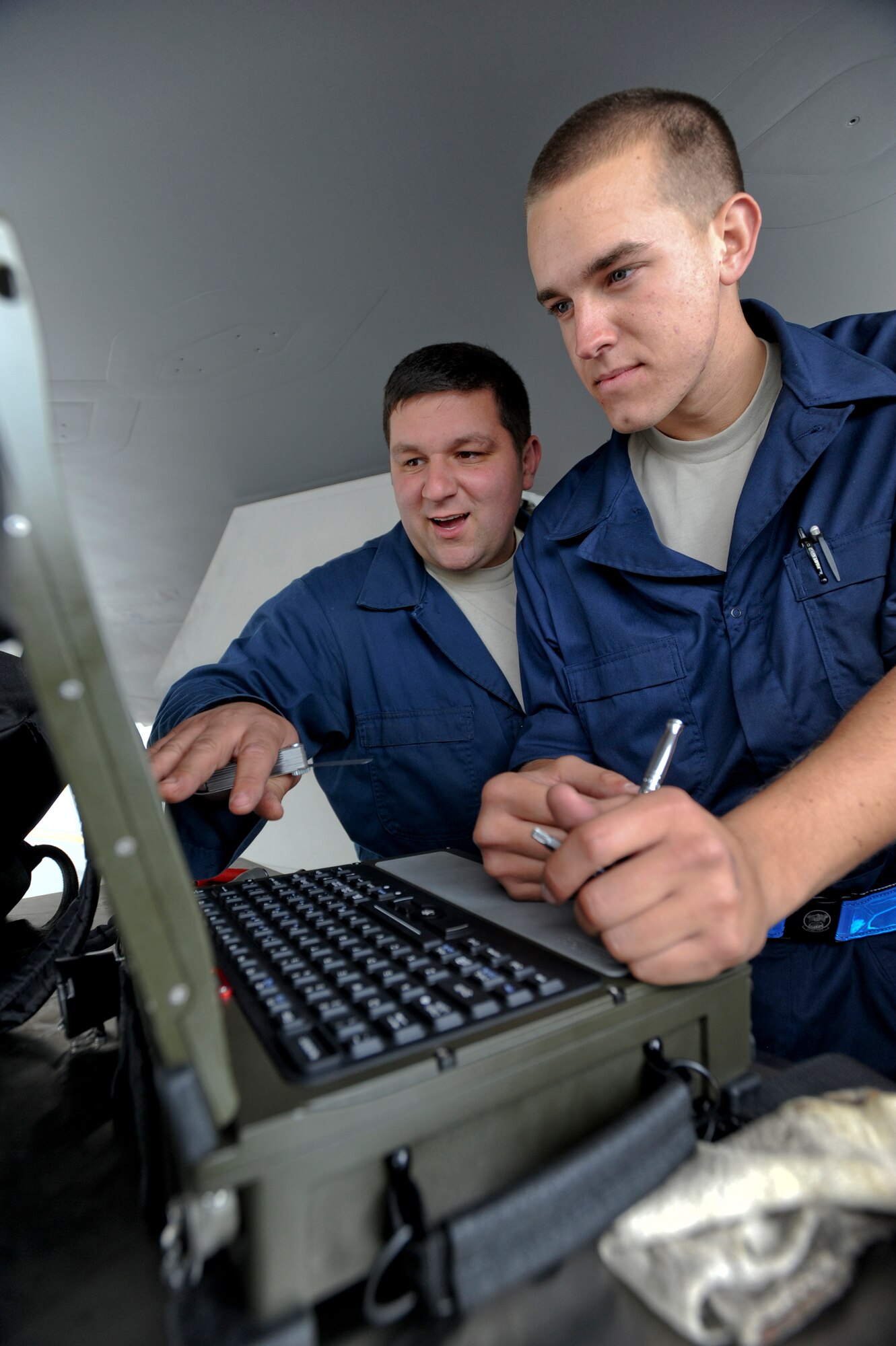 ELMENDORF AIR FORCE BASE, Alaska -- Staff Sgt. Jim Caruso and Airman 1st Class Joshua King, 525th Aircraft Maintenance Unit maintainers, review a technical order prior to performing maintenance on the internal counter measure door on an F-22A Raptor. Technical orders provide a step-by-step procedure to ensure that maintenance is performed efficiently and corrrectly. The internal counter measure door holds the counter measure flares for the aircraft. (U.S. Air Force photo/Staff Sgt. Joshua Garcia)